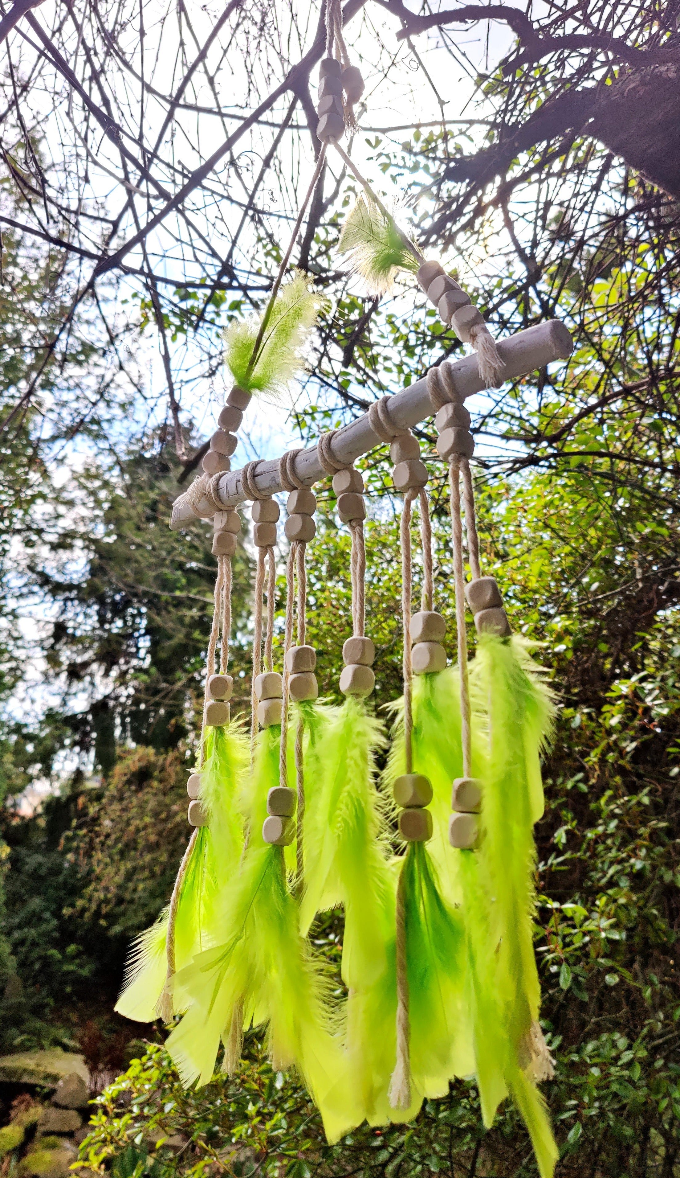 Handgefertigter Boho Deko Traumfänger im knalligen grün beige Farben Mix verziert mit Holzperlen, Makramee und Federn. Dekoration für dein Zuhause.