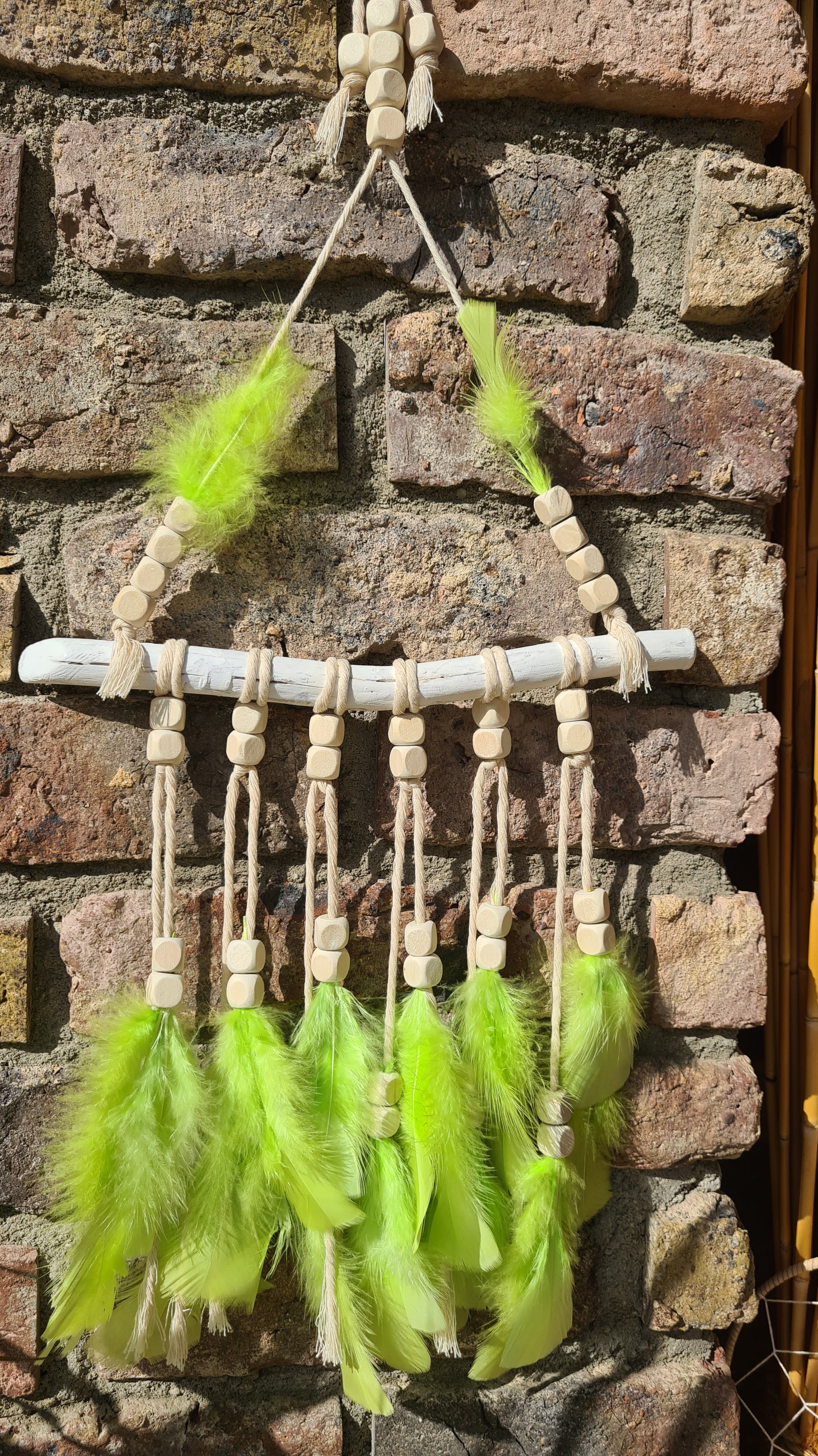 Handgefertigter Boho Deko Traumfänger im knalligen grün beige Farben Mix verziert mit Holzperlen, Makramee und Federn. Dekoration für dein Zuhause.