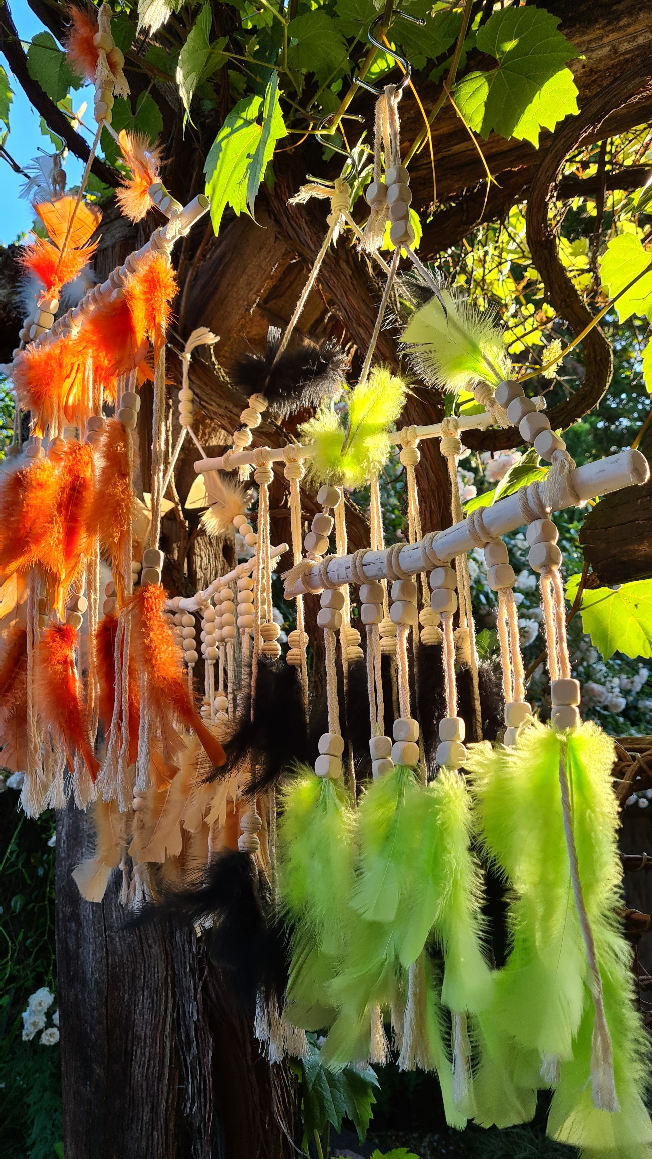 Handgefertigter Boho Deko Traumfänger im knalligen grün beige Farben Mix verziert mit Holzperlen, Makramee und Federn. Dekoration für dein Zuhause.