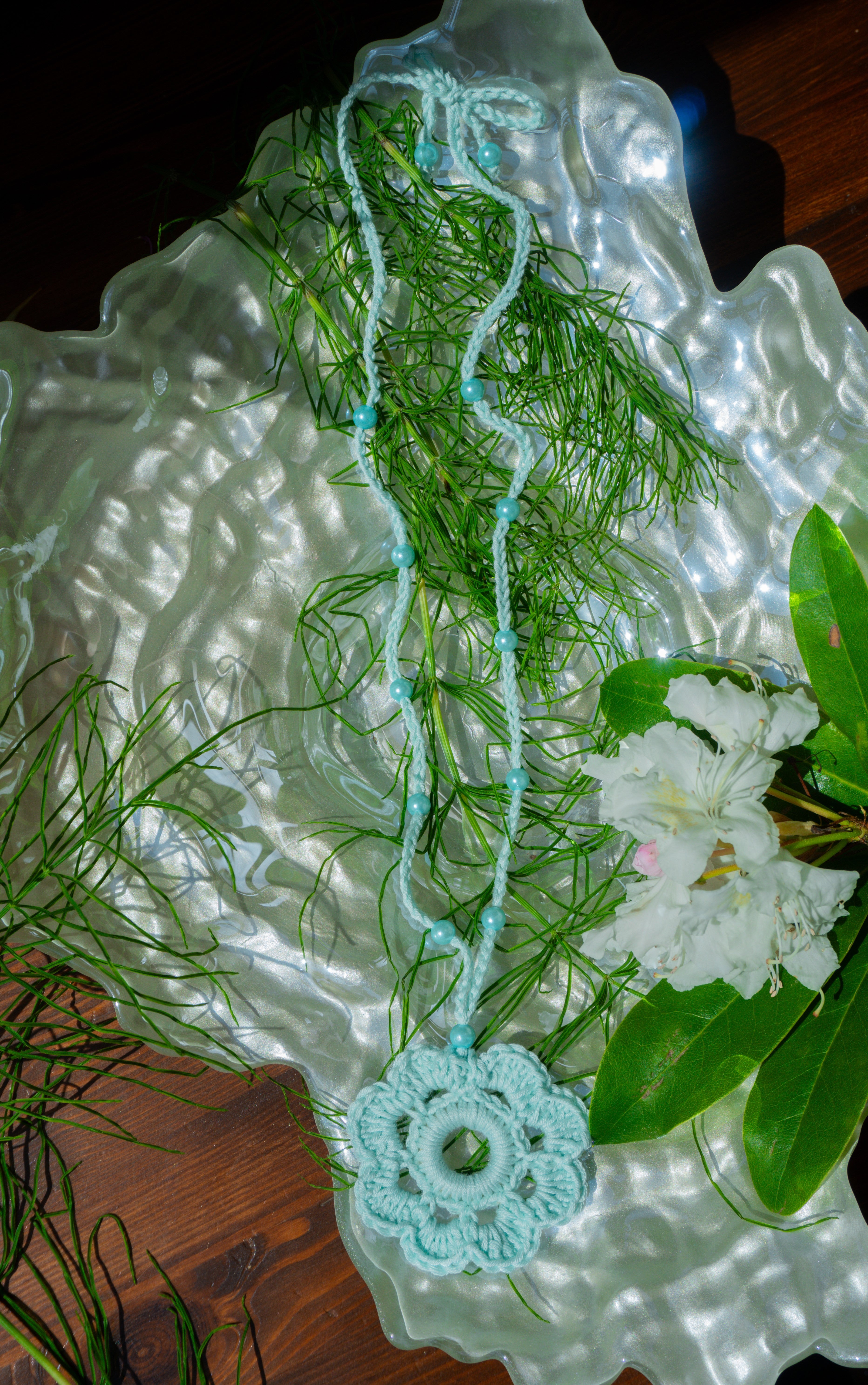 Verleihe deinem Sommerlook mit unserer handgefertigten Häkelkette in Hell Mint mit Häkelblumen-Anhänger und passenden Perlen eine individuelle Note. Entdecke stylische Möglichkeiten, um dein Outfit zu stylen und zeige deine verspielte Seite mit diesem einzigartigen Boho Accessoire.