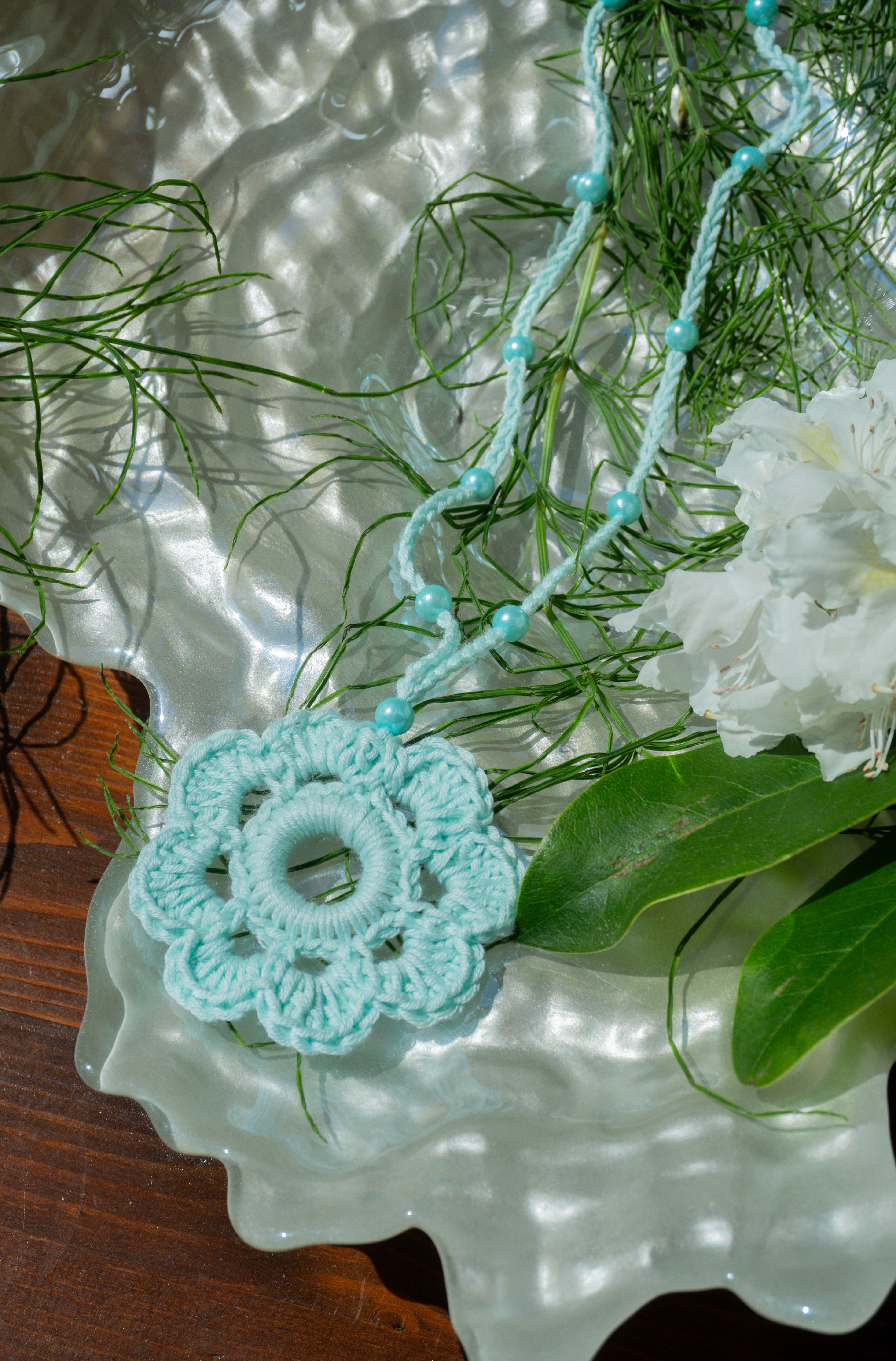 Verleihe deinem Sommerlook mit unserer handgefertigten Häkelkette in Hell Mint mit Häkelblumen-Anhänger und passenden Perlen eine individuelle Note. Entdecke stylische Möglichkeiten, um dein Outfit zu stylen und zeige deine verspielte Seite mit diesem einzigartigen Boho Accessoire.