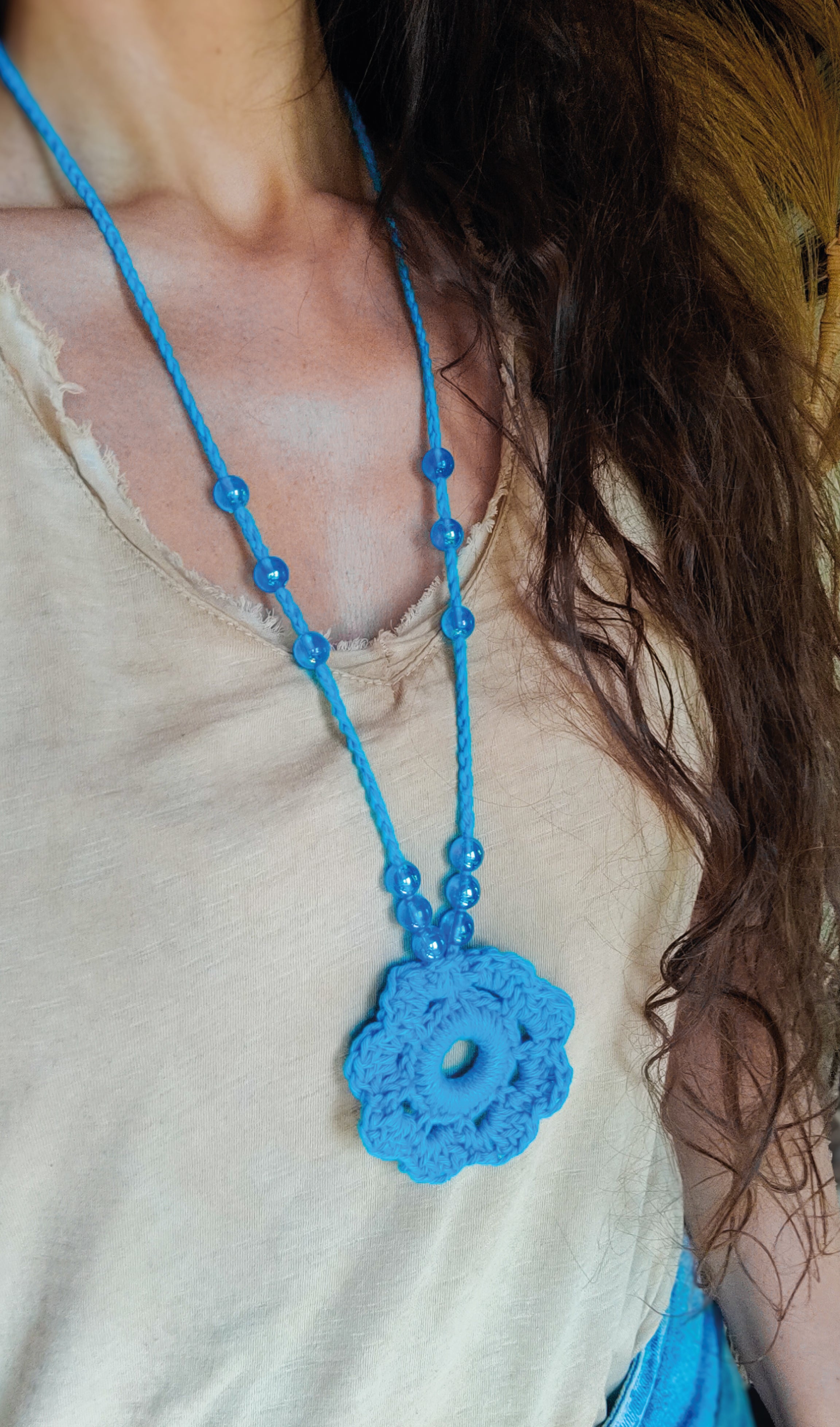 Verspieltes Design und sommerliche Farben - unsere handgefertigte Häkelkette in Türkis mit Blumenanhänger und passenden Perlen verleiht deinem Outfit einen Hauch von Individualität und ist das perfekte Boho Accessoire für den Sommerlook! Entdecke einzigartige und stylische Möglichkeiten, um dein Outfit zu stylen.