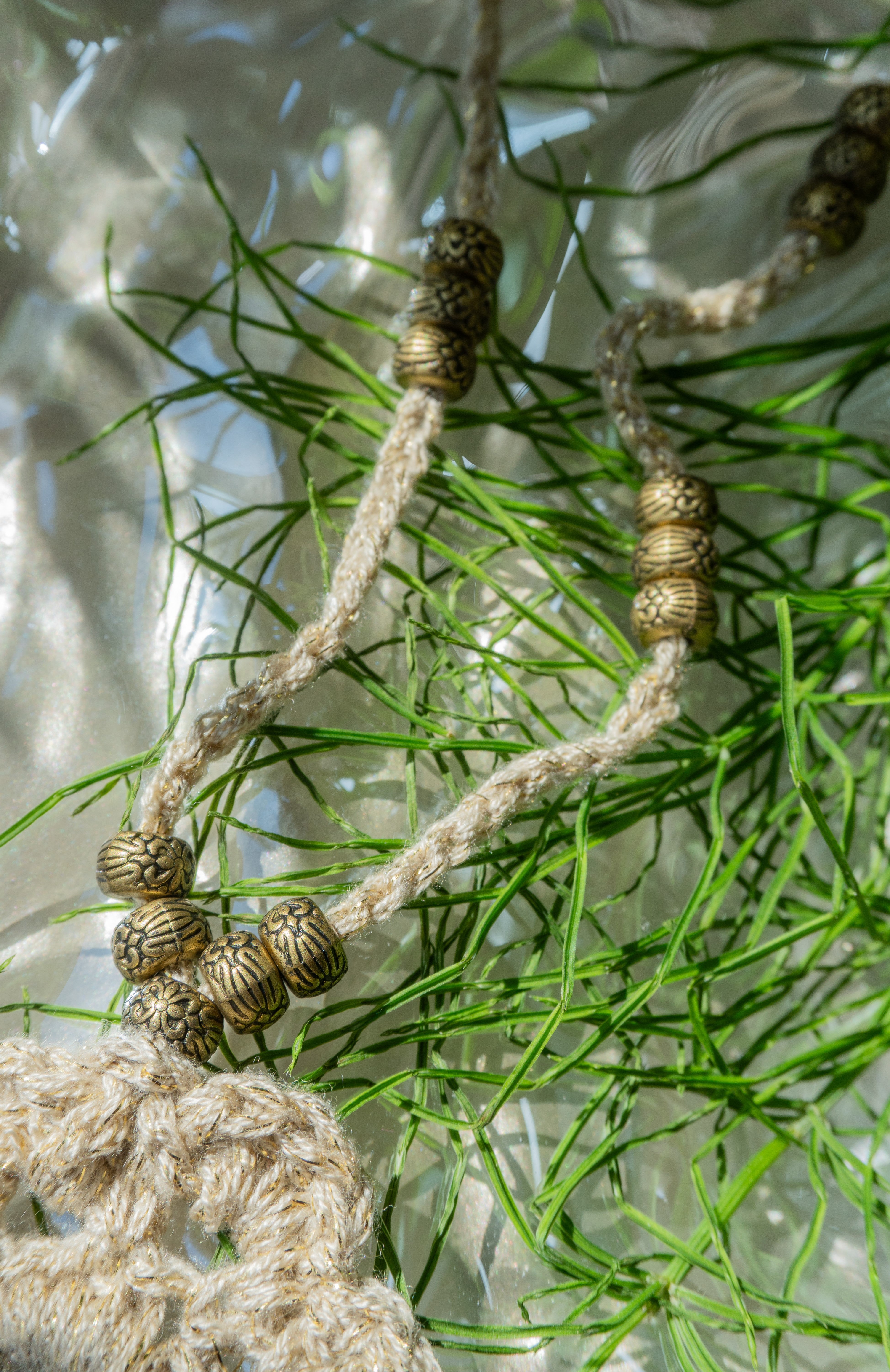 Verleihe deinem Boho Look einen Hauch von Eleganz mit unserer handgefertigten Häkelkette. Das Unikat besteht aus edlem metallic-gold Effektgarn und ist mit einem Häkel-Blumen Anhänger sowie passenden Ethno Style Perlen versehen. Perfekt als sommerliches Accessoire.