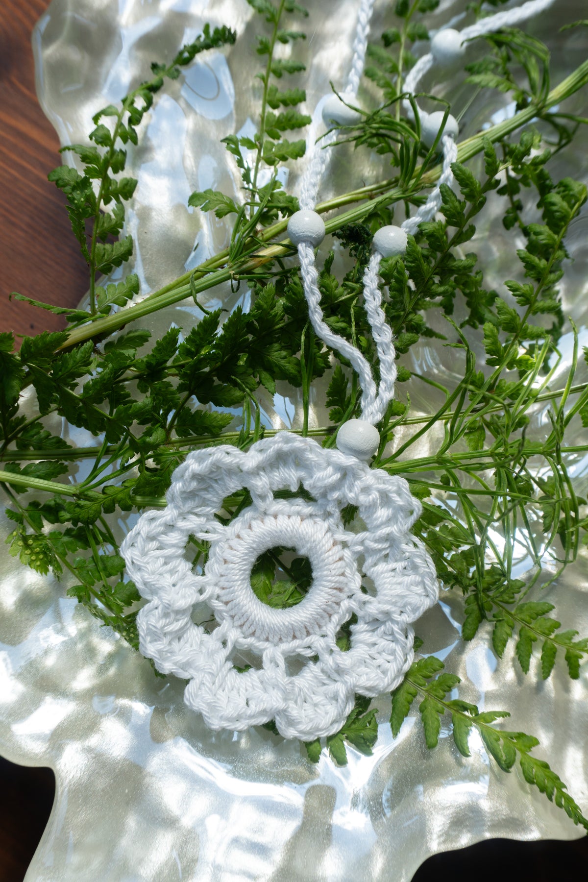 Weiße handgefertigte Häkelkette mit Häkelblumen-Anhänger. Leichter Boho Sommerschmuck im Ibiza Style für Sommer, Strand, Urlaub und Festival-Outfits.