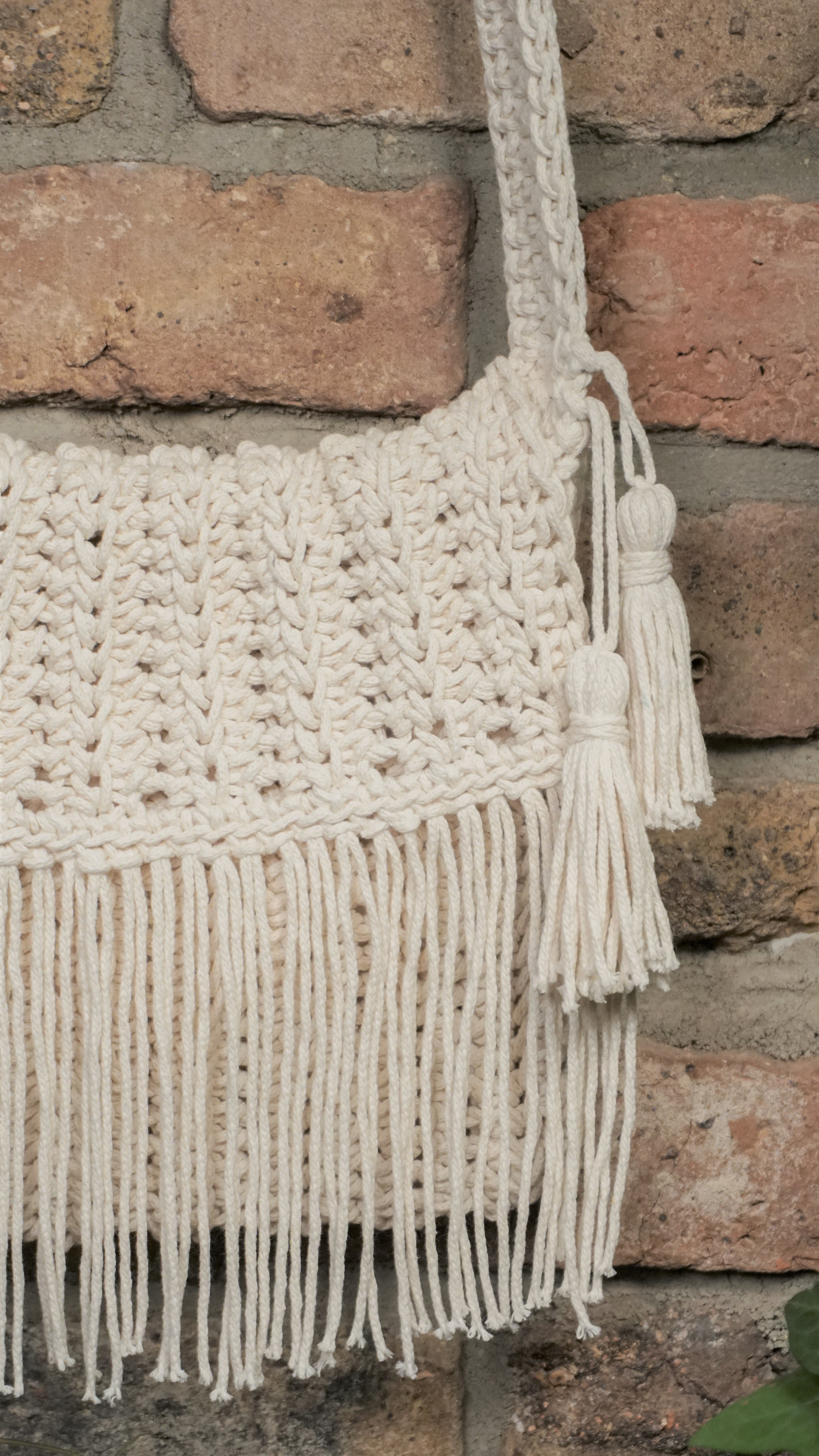 Unikat Damen Häkeltasche - Handtasche handgefertigt im Boho Hippie Ibiza -Stil mit Fransen und Taschenklappe als Verschluss in hell beige. Die perfekte Tasche für Festivals und als Accessoire zu deiner Sommermode.