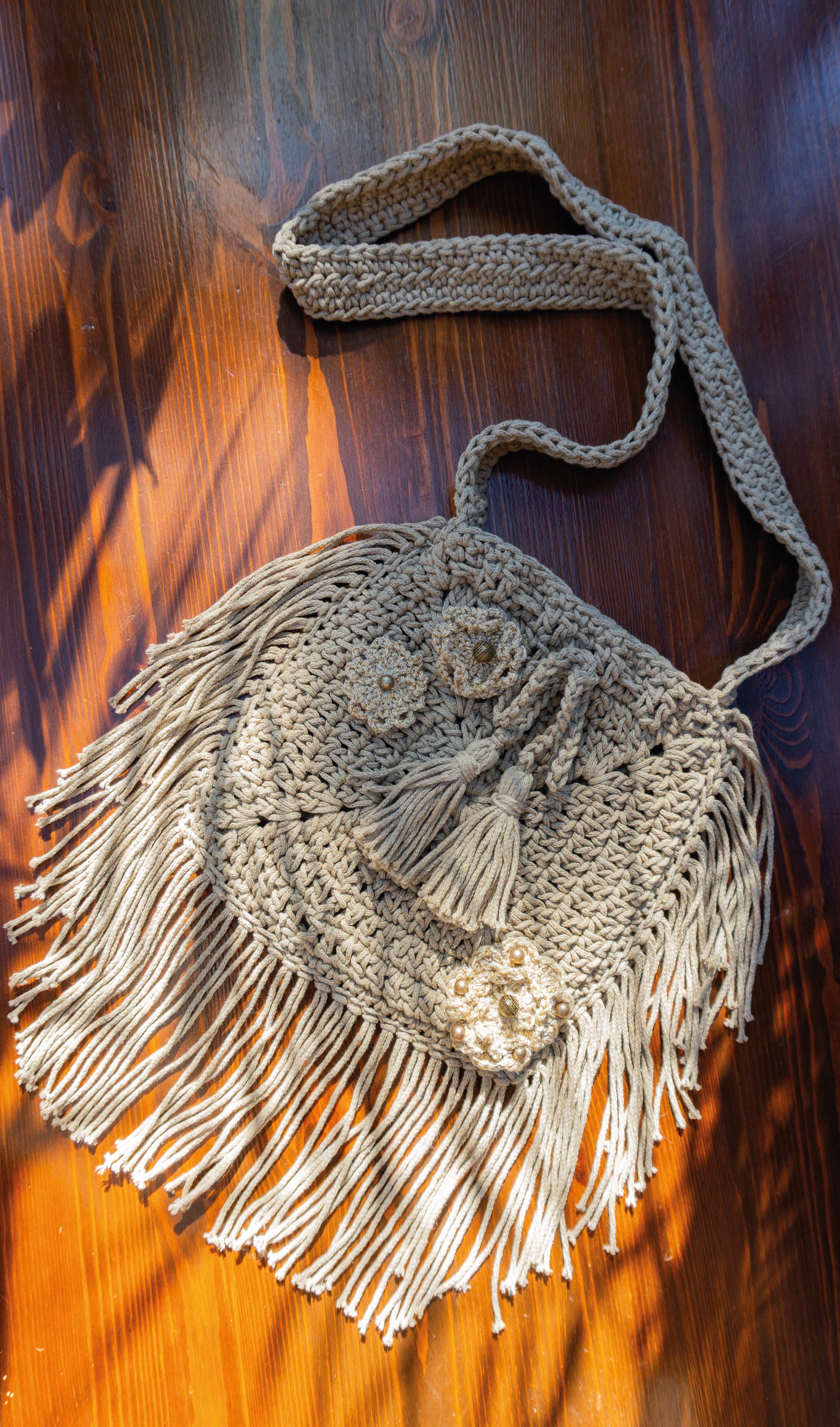 Diese Häkeltasche in Hell Khaki ist ein echtes Unikat mit Fransen und wunderschönen Blumenapplikationen in Metallic-Optik. Sie ist die perfekte Ergänzung für dein Festival- und Bohemian-Outfit oder ein toller Eyecatcher im Alltag. Lass dich von ihrem besonderen Charme verzaubern!