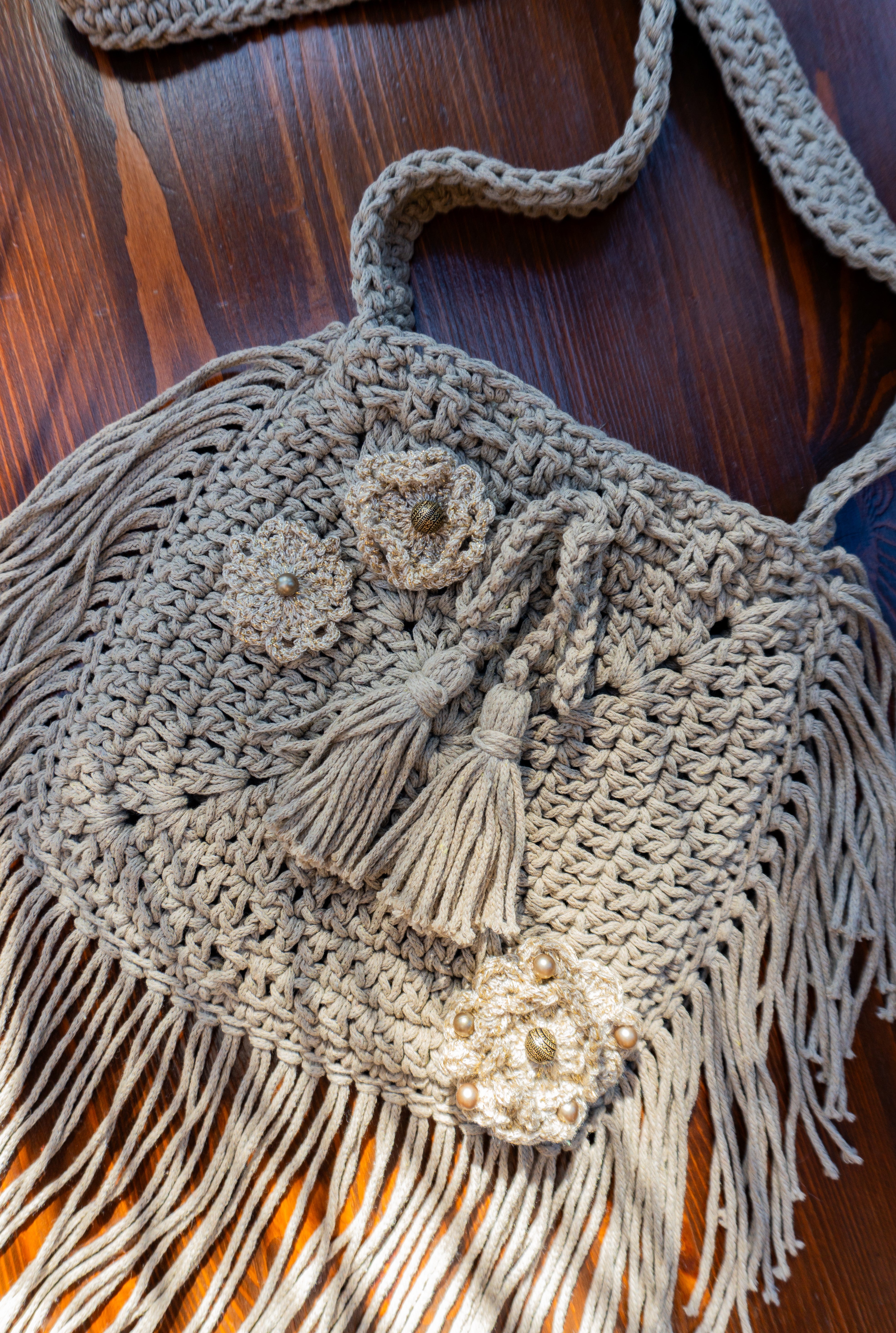 Diese Häkeltasche in Hell Khaki ist ein echtes Unikat mit Fransen und wunderschönen Blumenapplikationen in Metallic-Optik. Sie ist die perfekte Ergänzung für dein Festival- und Bohemian-Outfit oder ein toller Eyecatcher im Alltag. Lass dich von ihrem besonderen Charme verzaubern!