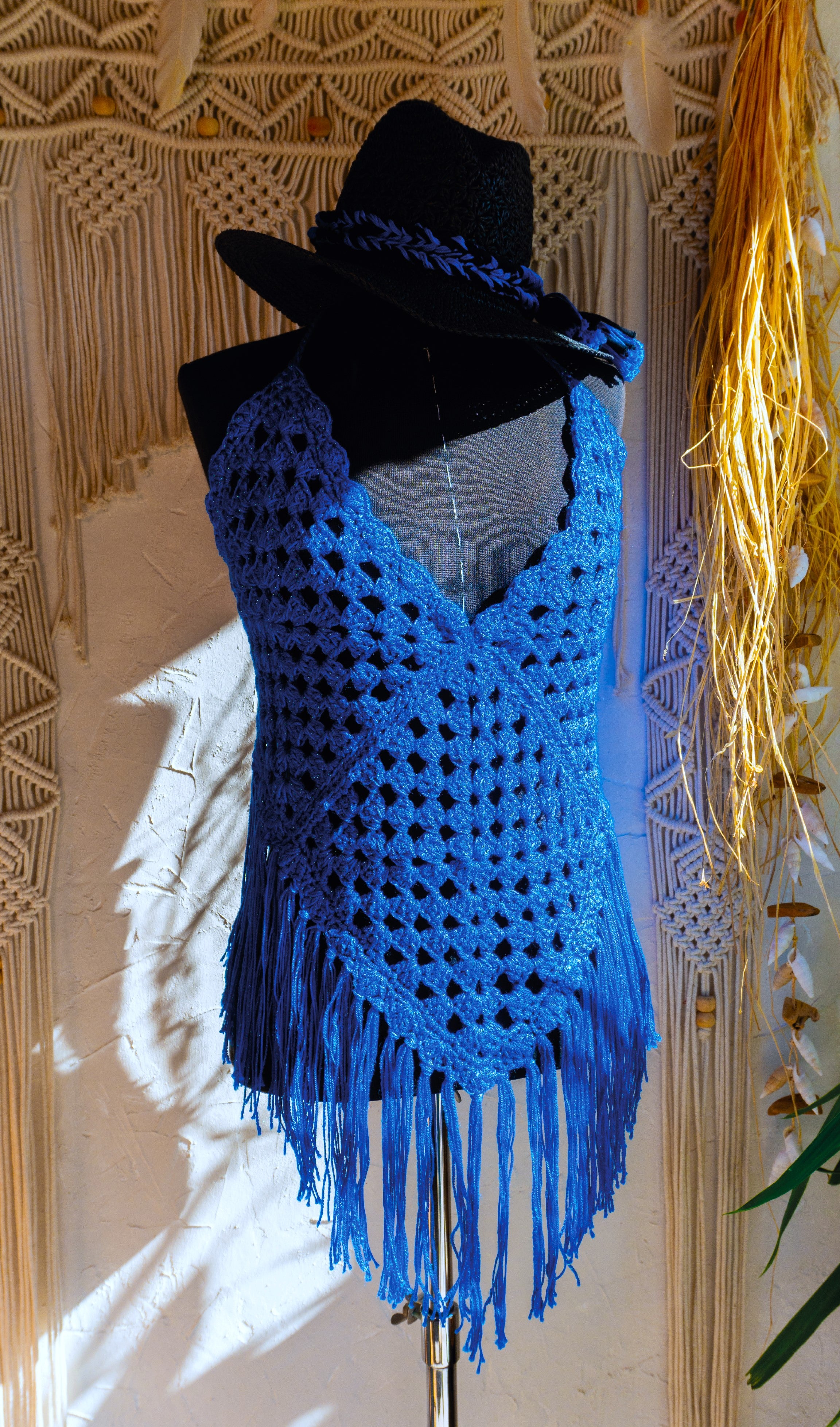 Das handgefertigte Häkeltop in strahlendem Königsblau mit Metallic-Effekt Garn und Fransen ist der ideale Begleiter für Festivals, Strandtage und den Sommer! Die verstellbaren Bänder am Nacken und Rücken sorgen für bequemen Tragekomfort. Die Verwendung von hochwertiger merzerisierter Baumwolle verleiht dem Top eine besonders weiche Textur.