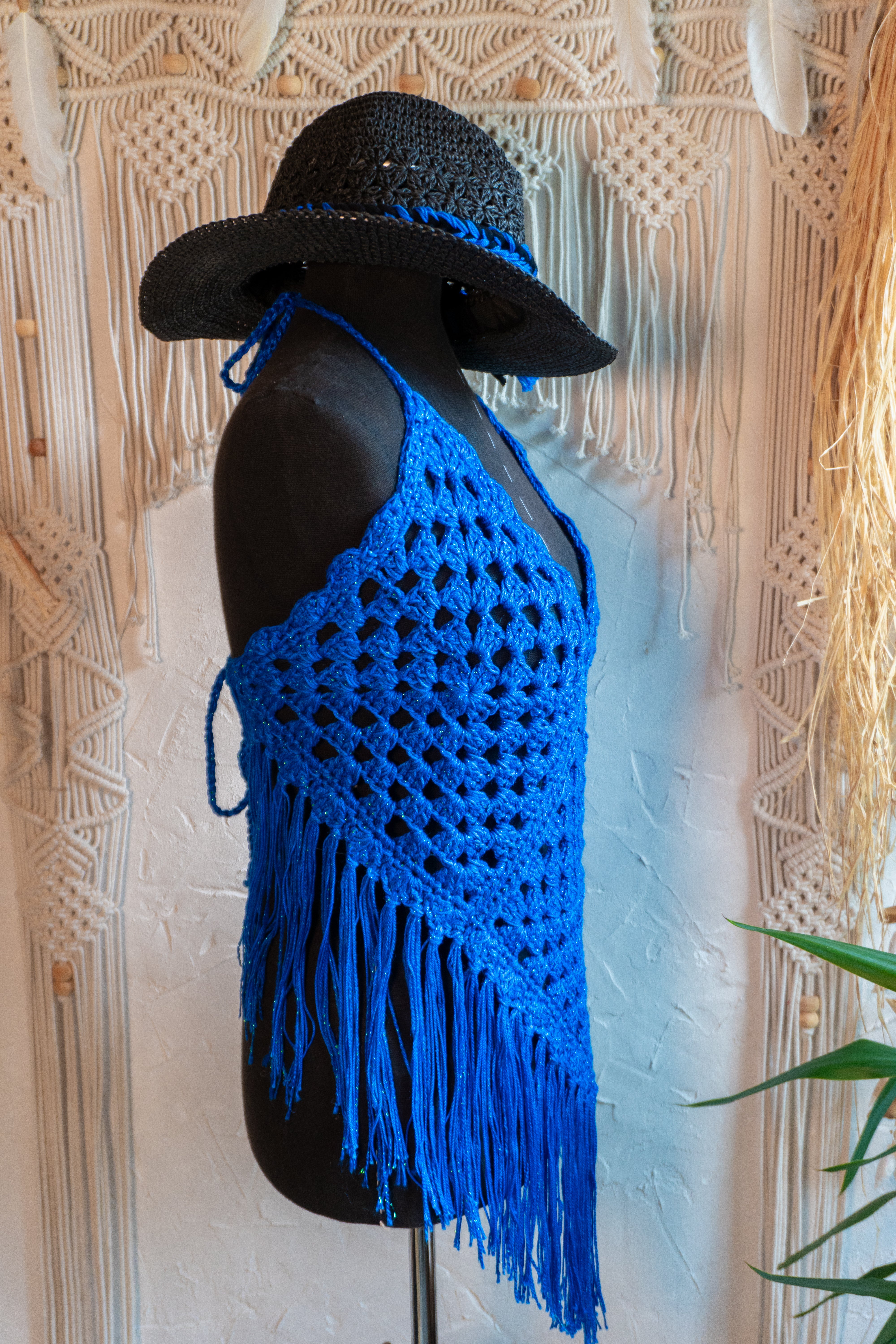 Das handgefertigte Häkeltop in strahlendem Königsblau mit Metallic-Effekt Garn und Fransen ist der ideale Begleiter für Festivals, Strandtage und den Sommer! Die verstellbaren Bänder am Nacken und Rücken sorgen für bequemen Tragekomfort. Die Verwendung von hochwertiger merzerisierter Baumwolle verleiht dem Top eine besonders weiche Textur.