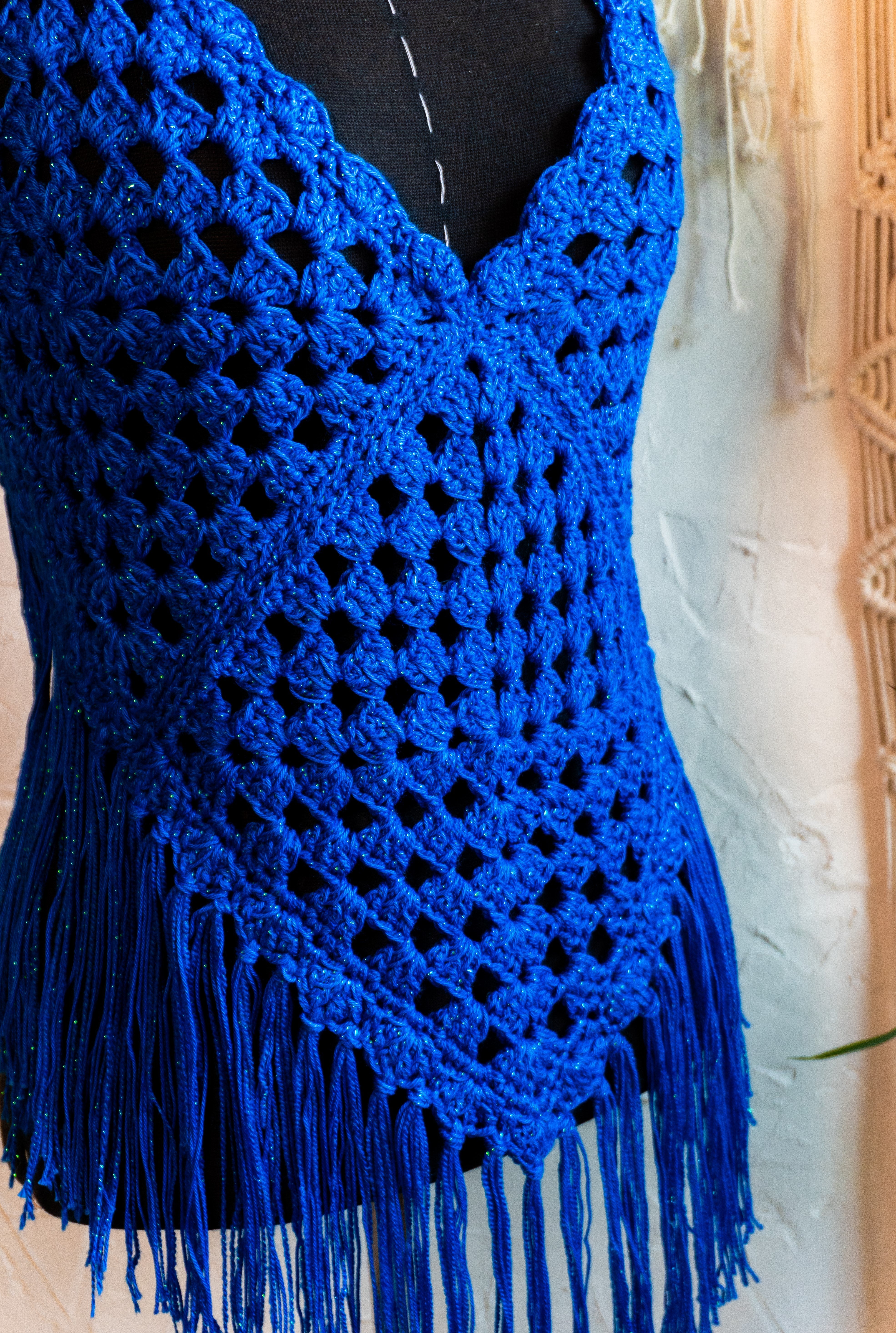 Das handgefertigte Häkeltop in strahlendem Königsblau mit Metallic-Effekt Garn und Fransen ist der ideale Begleiter für Festivals, Strandtage und den Sommer! Die verstellbaren Bänder am Nacken und Rücken sorgen für bequemen Tragekomfort. Die Verwendung von hochwertiger merzerisierter Baumwolle verleiht dem Top eine besonders weiche Textur.