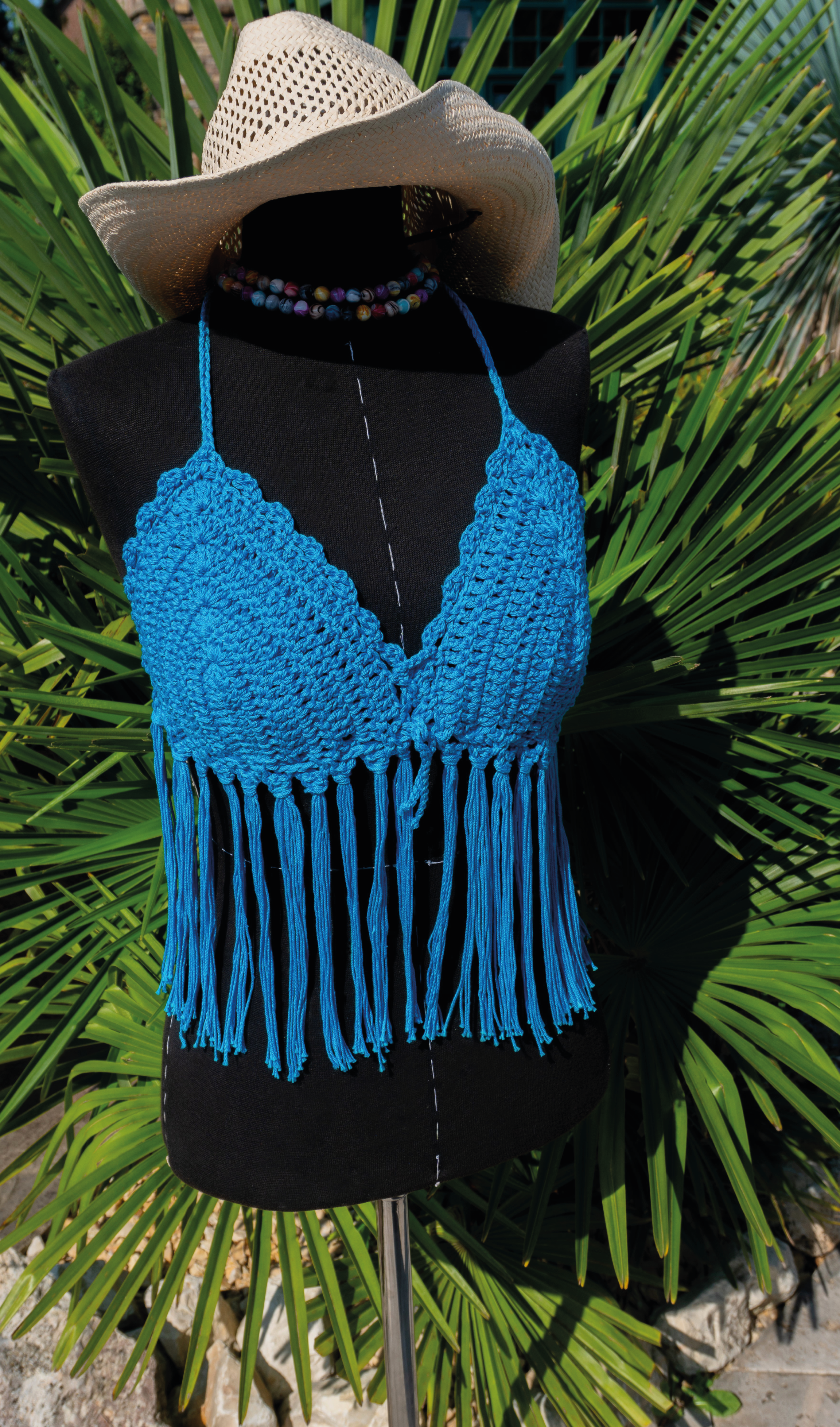 Handgefertigtes Häkeltop in leuchtendem Türkis mit Fransen ist der ideale Begleiter für Festivals, Strandtage und den Sommer! Die verstellbaren Bänder am Nacken und Rücken sorgen für bequemen Tragekomfort. Aus hochwertiger merzerisierter Baumwolle.