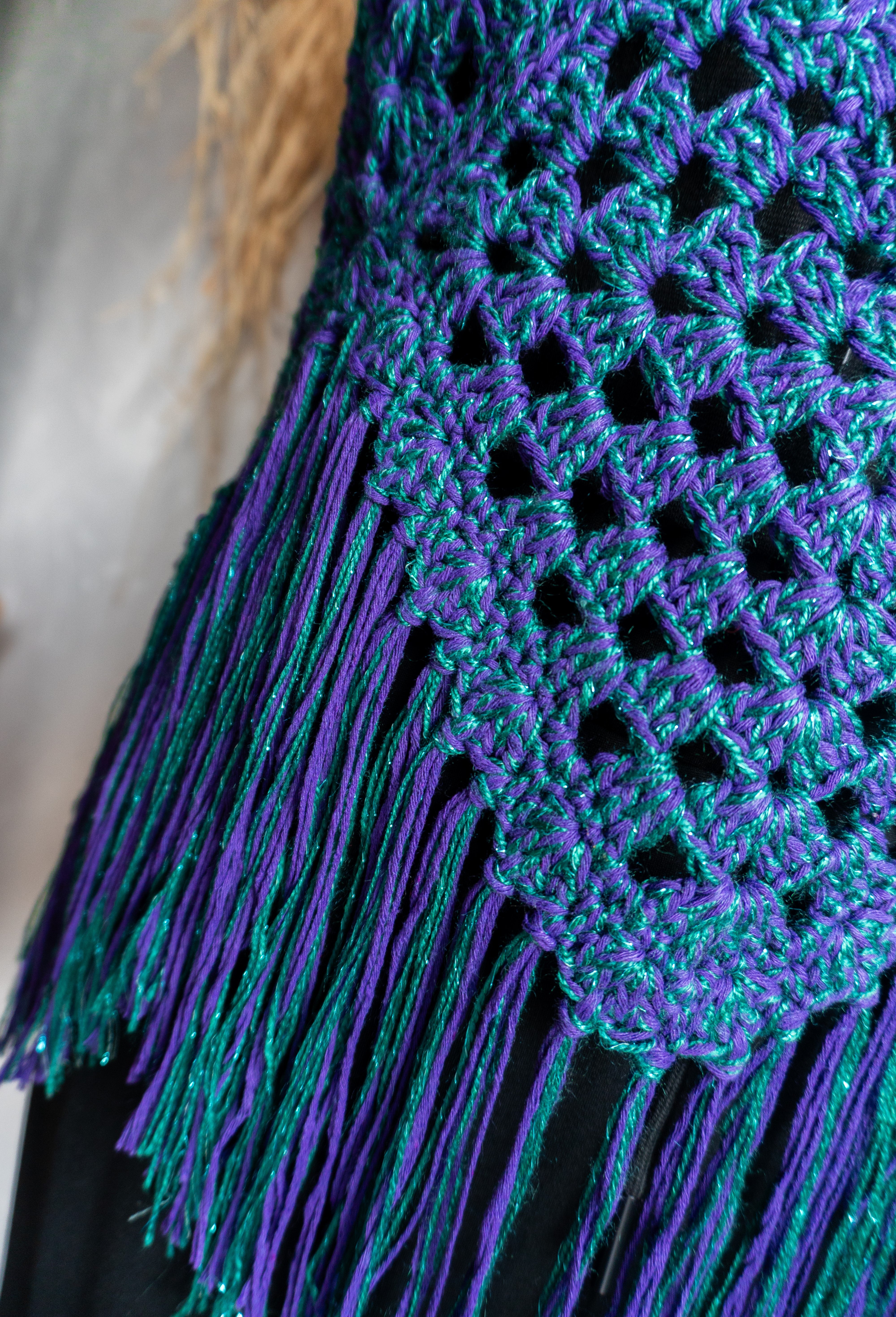 Handgefertigtes Unikat Häkeltop in einem auffälligen Farbmix aus Lila-Grün Metallic - ein stylisher Hingucker! Perfekt für ein stylisches Boho-inspiriertes Outfit. Individuell anpassbare Neckholder-Träger und Rückenbänder sorgen für perfekten Sitz und ein angenehmes Hautgefühl. Die stylischen Fransen verleihen dem Top eine lässige Note und machen es zum absoluten Must-have. Kombiniere es nach Bedarf mit einem passenden Bikini Oberteil darunter. Mit Liebe in Deutschland handgefertigt.