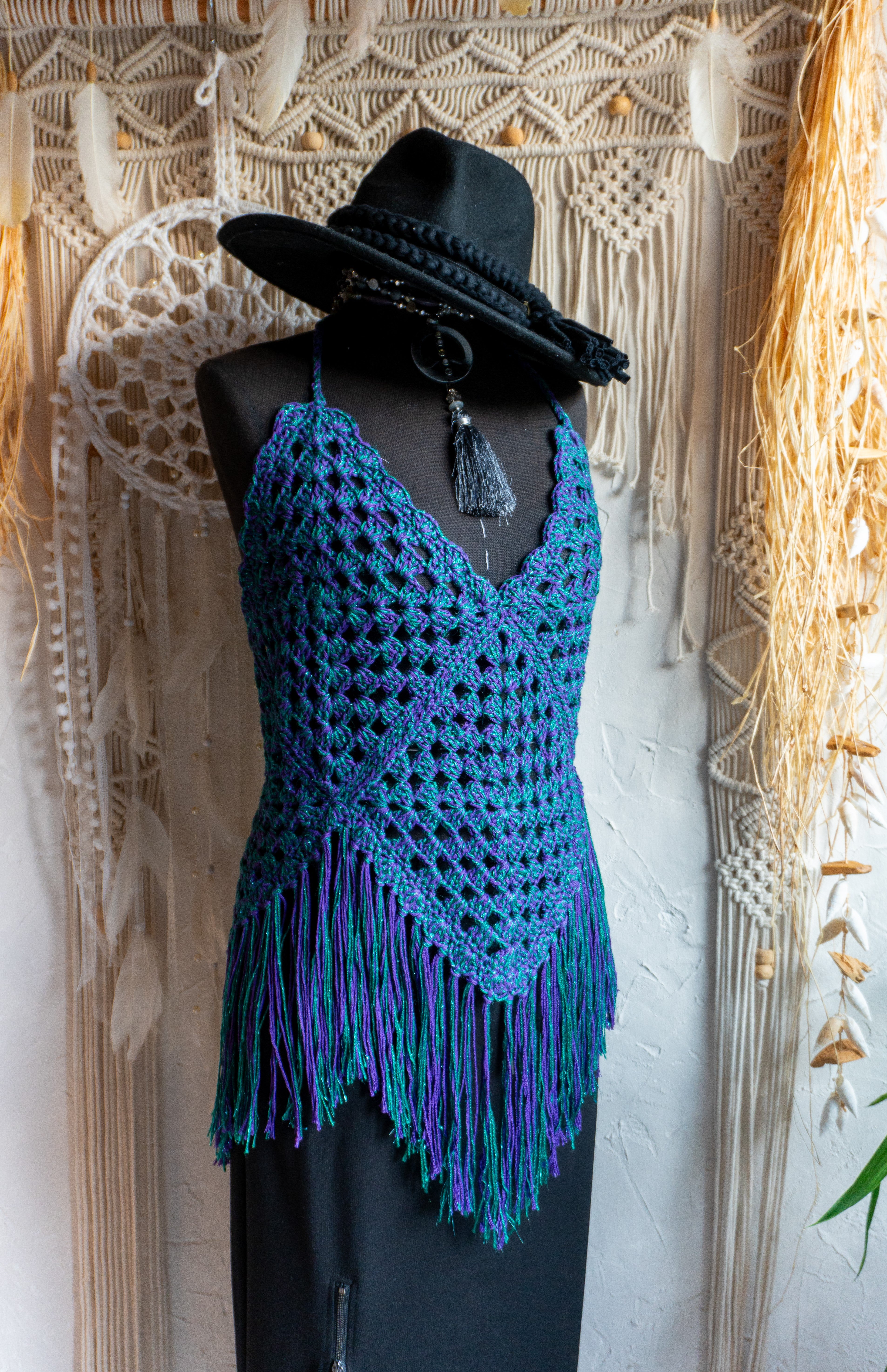 Handgefertigtes Unikat Häkeltop in einem auffälligen Farbmix aus Lila-Grün Metallic - ein stylisher Hingucker! Perfekt für ein stylisches Boho-inspiriertes Outfit. Individuell anpassbare Neckholder-Träger und Rückenbänder sorgen für perfekten Sitz und ein angenehmes Hautgefühl. Die stylischen Fransen verleihen dem Top eine lässige Note und machen es zum absoluten Must-have. Kombiniere es nach Bedarf mit einem passenden Bikini Oberteil darunter. Mit Liebe in Deutschland handgefertigt.