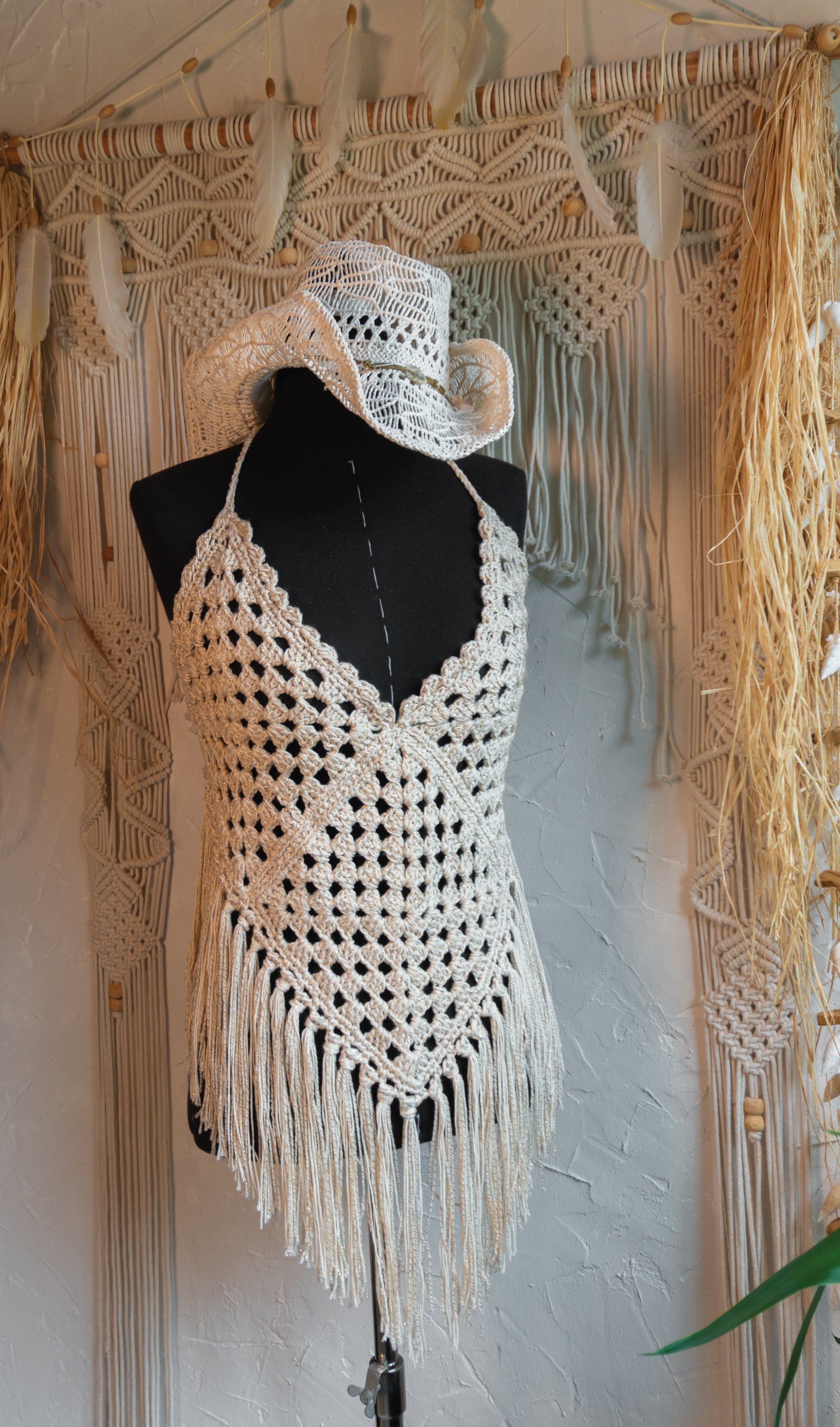 Das handgefertigte Häkeltop in Beige-Gold ist perfekt für den Hippe Boho Style und besticht durch den Mix mit edlem Metalliceffekt-Garn. Mit individuell verstellbaren Trägern im Nacken und am Rücken passt es sich jeder Figur an und sorgt für ein bequemes Tragegefühl. Ideal für Festivals, Strandbesuche oder den sommerlichen Look.