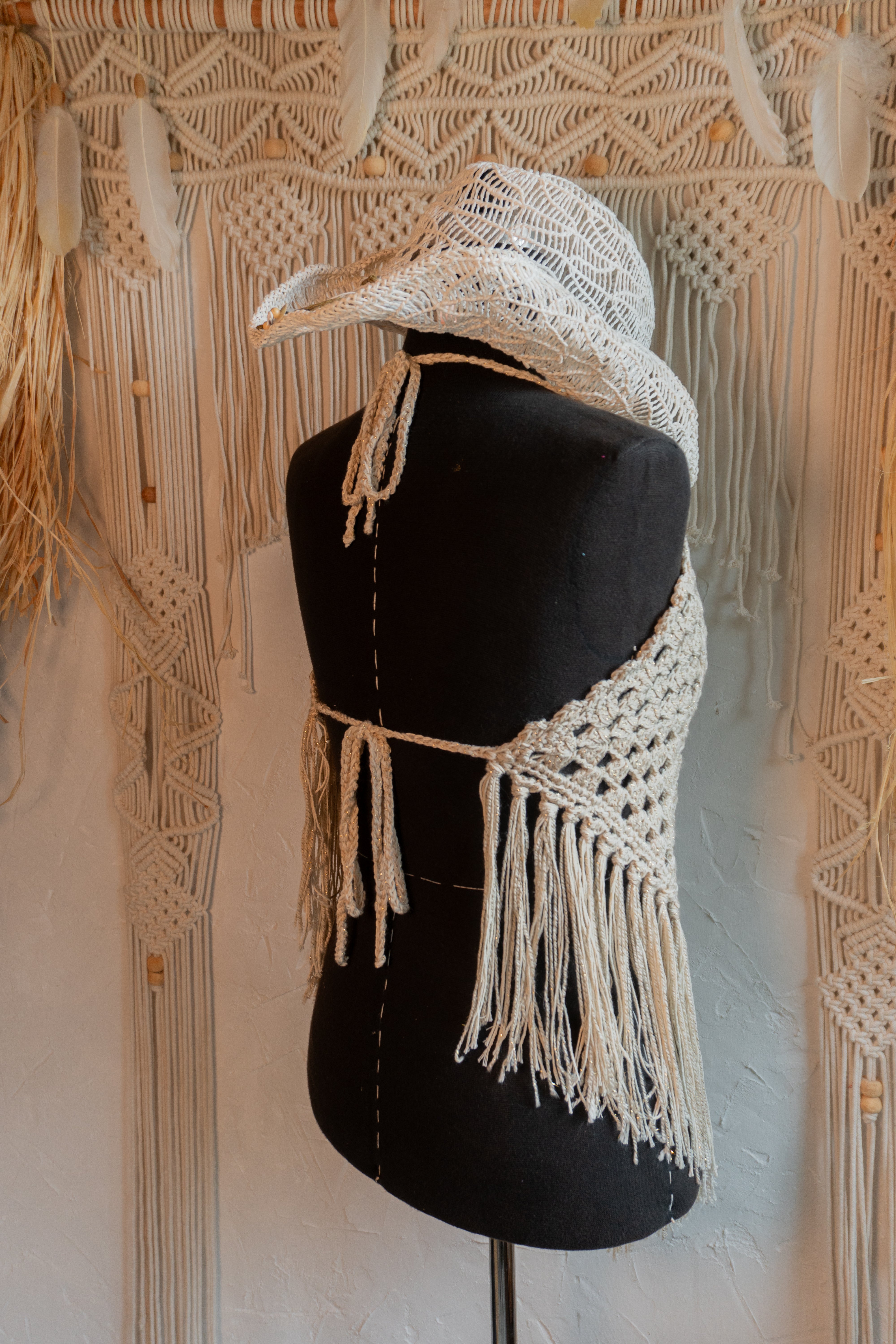 Das handgefertigte Häkeltop in Beige-Gold ist perfekt für den Hippe Boho Style und besticht durch den Mix mit edlem Metalliceffekt-Garn. Mit individuell verstellbaren Trägern im Nacken und am Rücken passt es sich jeder Figur an und sorgt für ein bequemes Tragegefühl. Ideal für Festivals, Strandbesuche oder den sommerlichen Look.