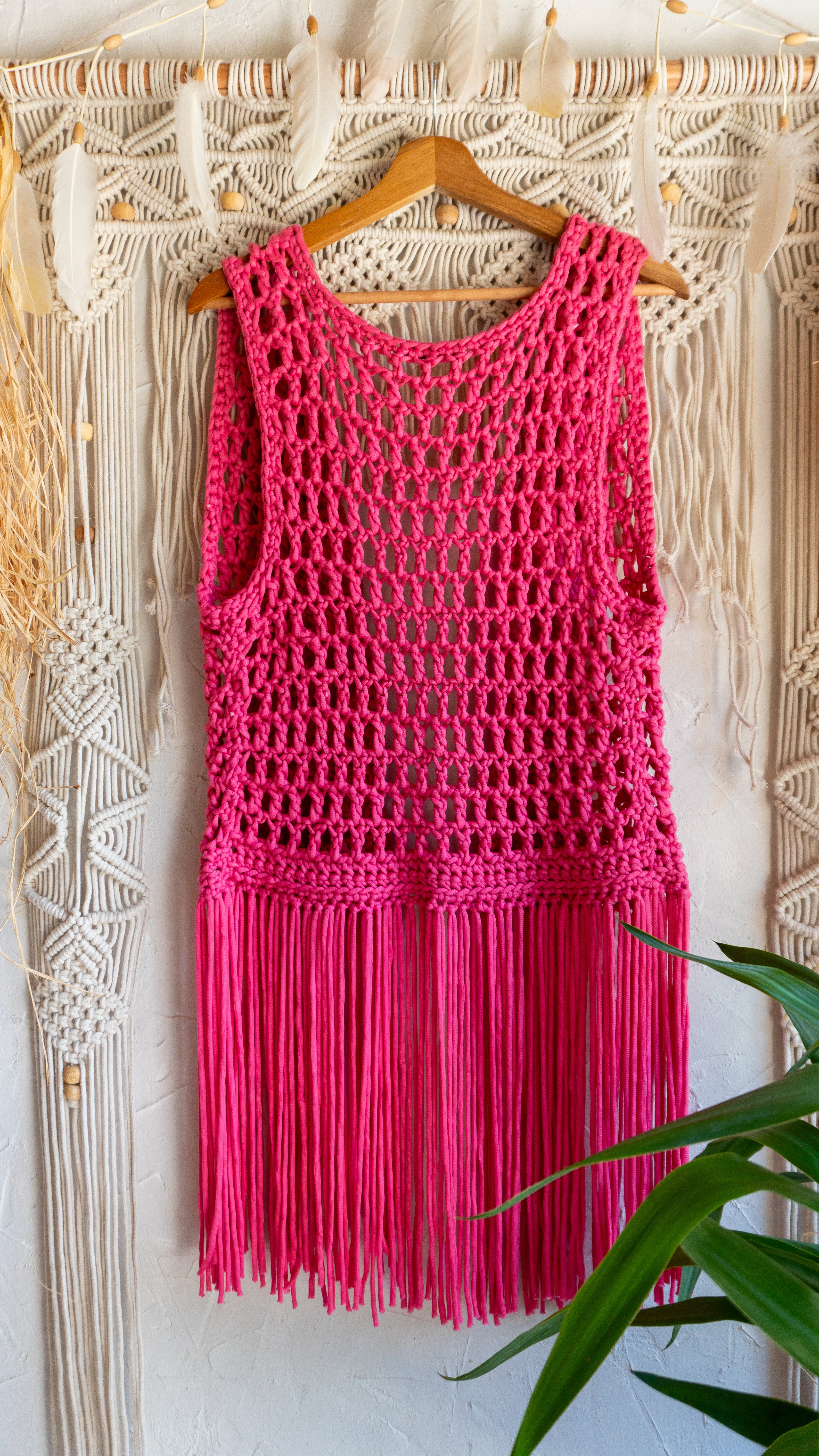 Handgefertigte knallig pinke Fransen Häkelweste im Boho Hippie-Ibiza-Stil für Frauen. Stylisches Mode Accessoire für Festival- und Sommeroutfits.