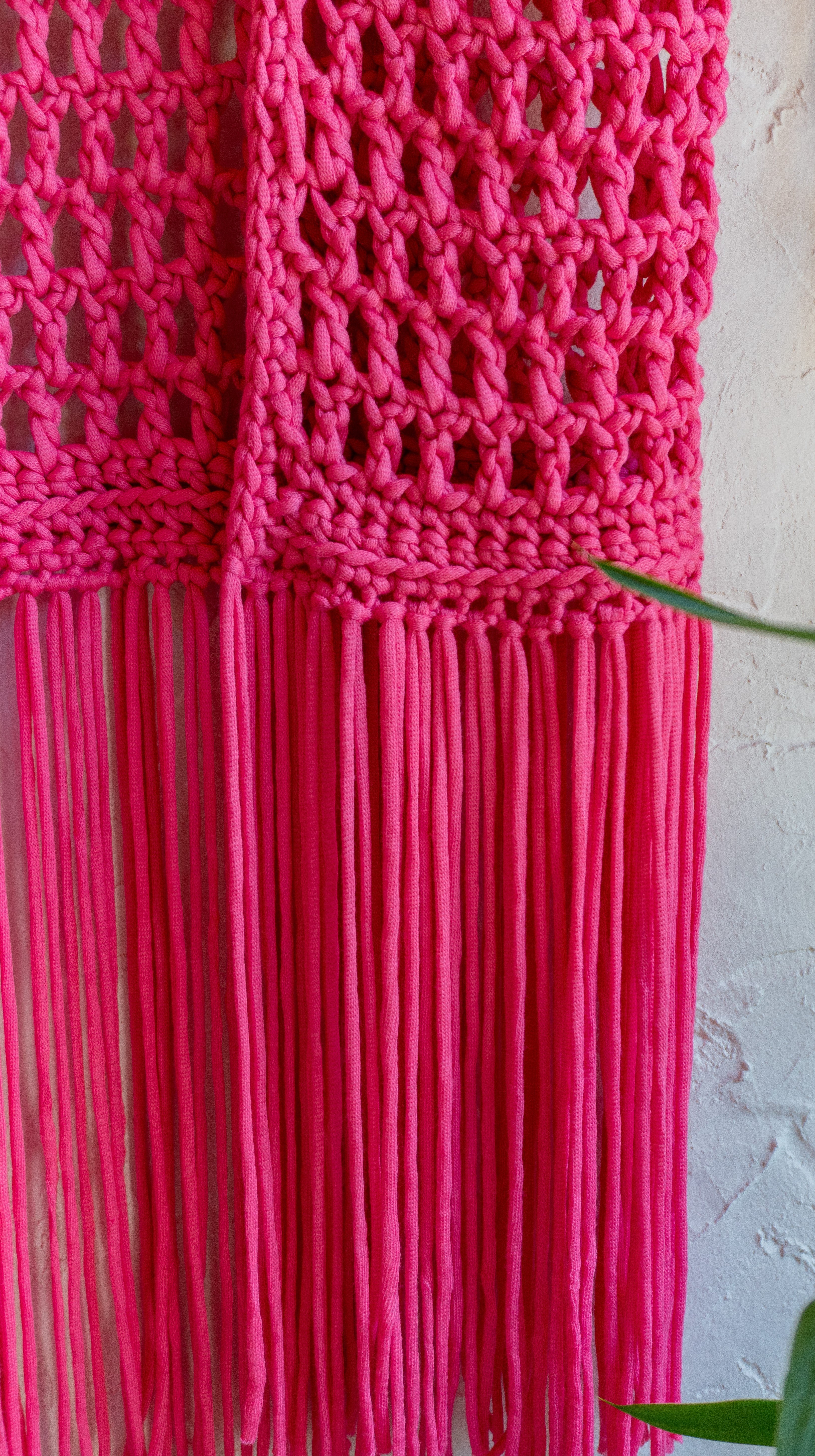 Handgefertigte knallig pinke Fransen Häkelweste im Boho Hippie-Ibiza-Stil für Frauen. Stylisches Mode Accessoire für Festival- und Sommeroutfits.