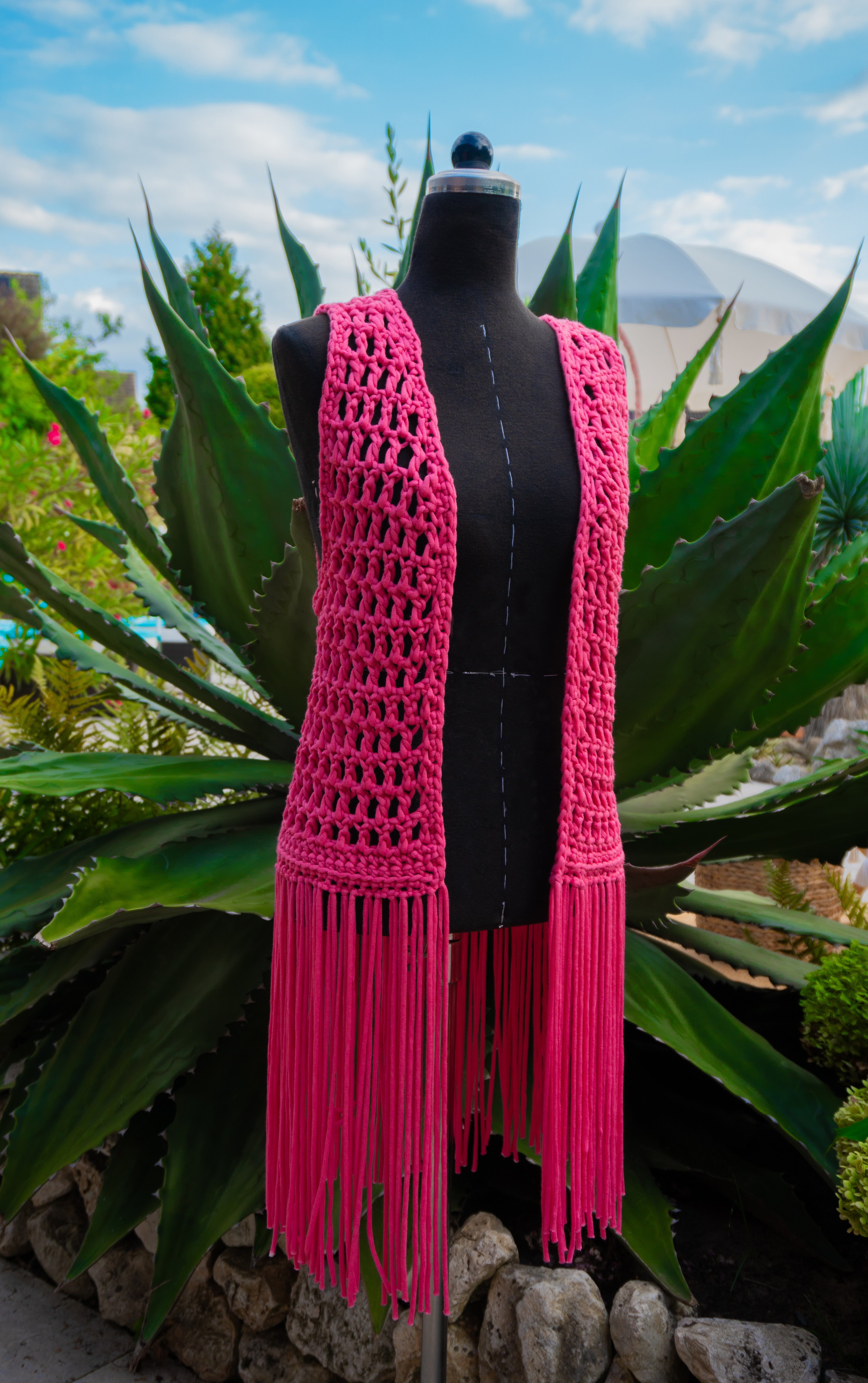 Handgefertigte knallig pinke Fransen Häkelweste im Boho Hippie-Ibiza-Stil für Frauen. Stylisches Mode Accessoire für Festival- und Sommeroutfits.