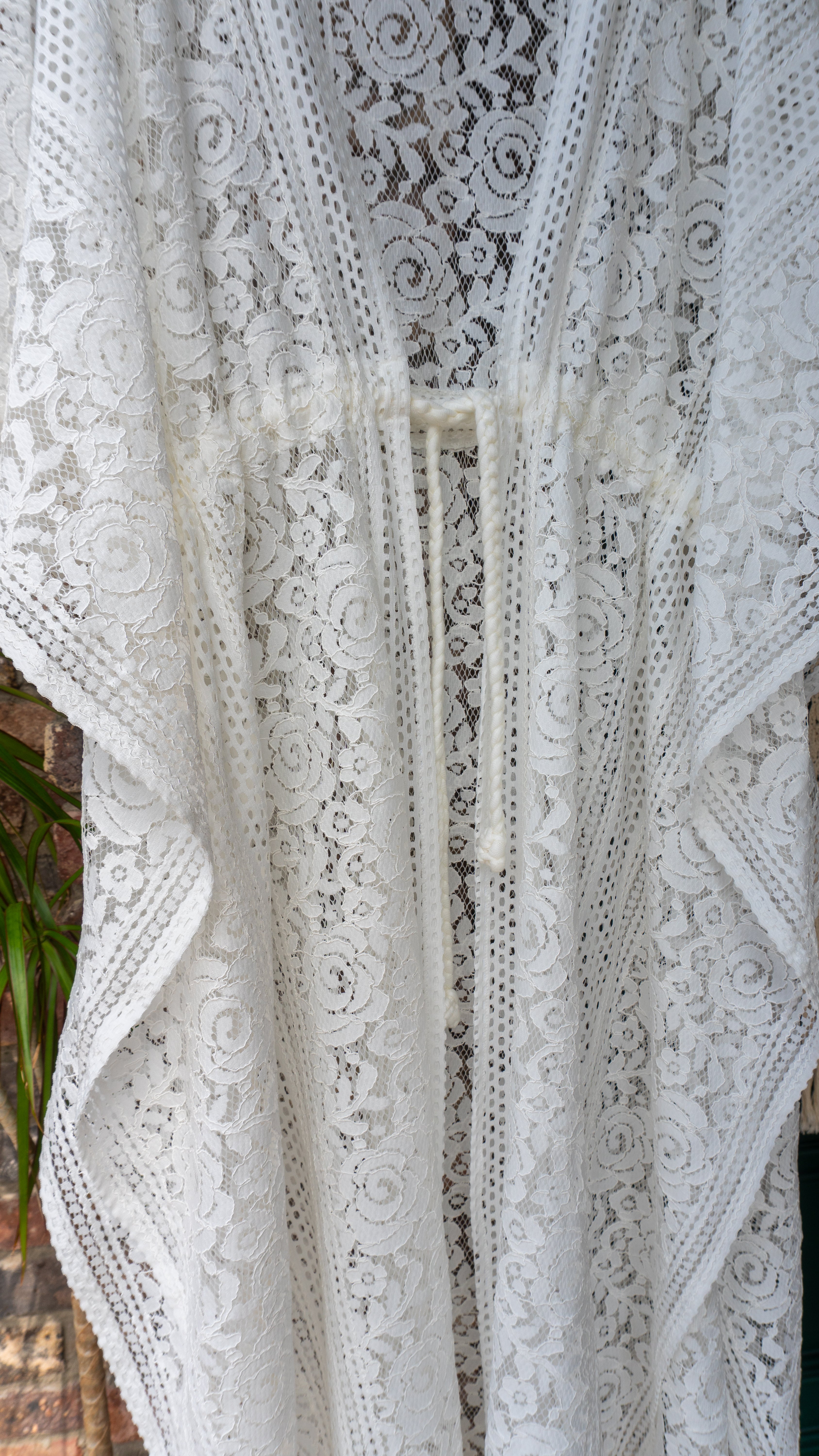 Blüten-Spitze Kimono in warmweiß handgefertigt in Deutschland. Exklusiv und limitiert im Bohemian Stil mit Schlitzen an den Seiten und Taillen Raffung Kordelzug. Romantisches Unikat Design mit Boho Hochzeit Vibes.