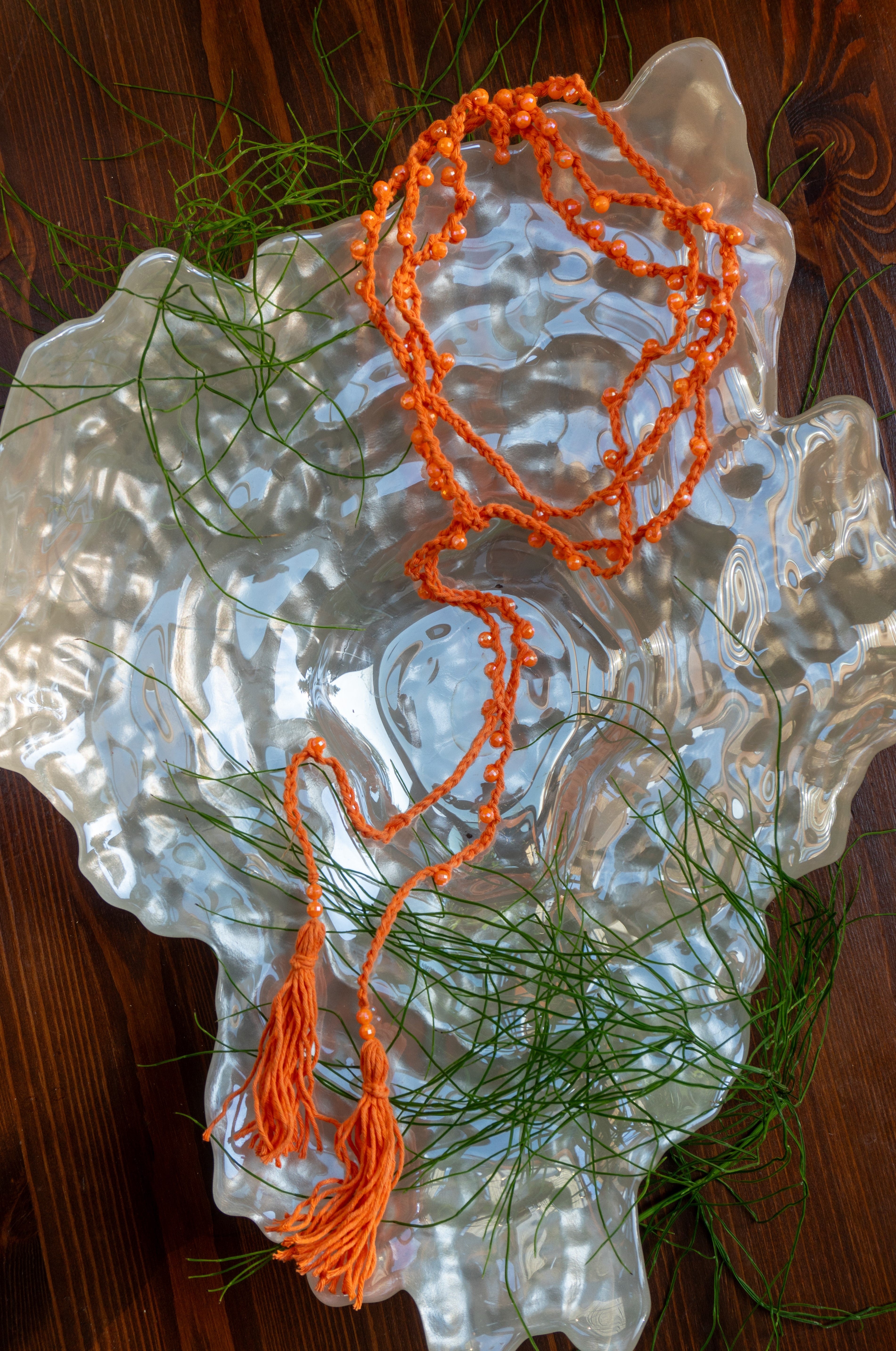 Handgemachte orangefarbene Boho-Häkelkette mit Perlen, variabel tragbar als Halskette, Armband oder Taillengürtel – Ibiza-Style Schmuck für Sommerlooks.