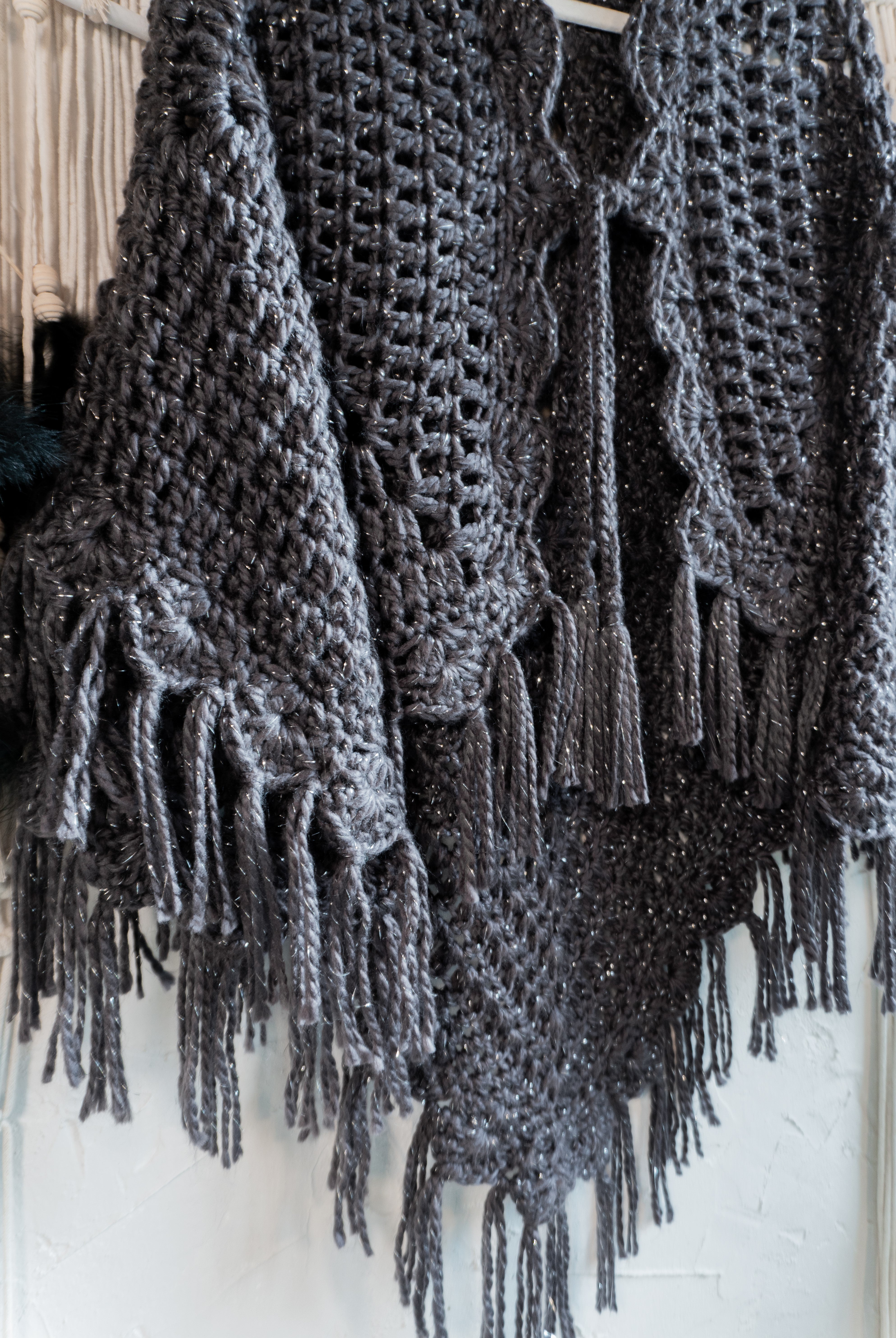 Verleihe deinem Herbst- oder Übergangsoutfit mit dieser absolut exklusiven Einzelstück Häkel Poncho-Jacke in edlem Anthrazit-Metallic und mit schönen Fransen den besonderen Boho-Chic Touch. Die Bänder am Ausschnitt sorgen nicht nur für eine tolle Optik, sondern auch für einen bequemen Sitz. Ein Must-Have für alle, die sich gerne von der Masse abheben wollen!