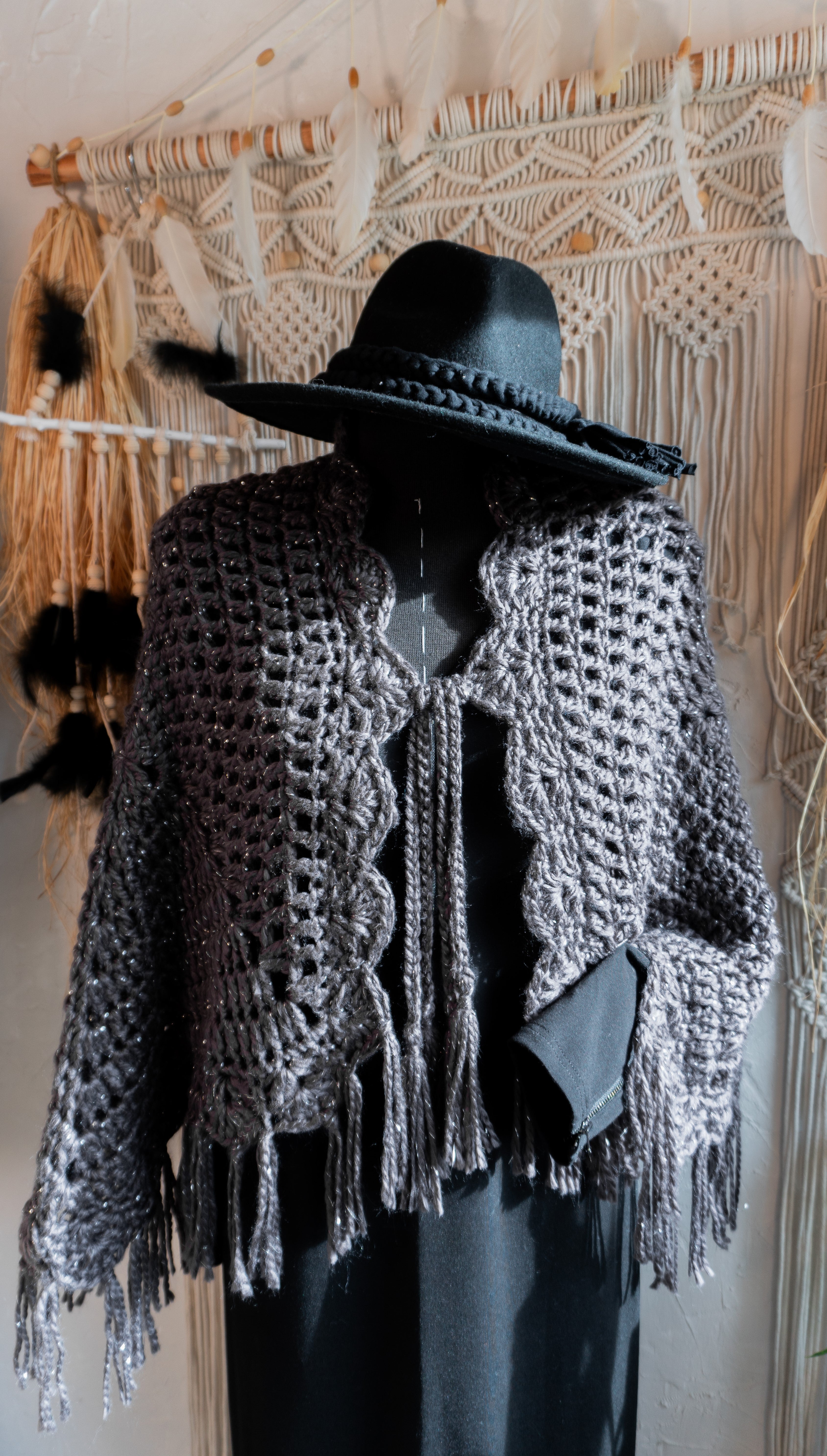Verleihe deinem Herbst- oder Übergangsoutfit mit dieser absolut exklusiven Einzelstück Häkel Poncho-Jacke in edlem Anthrazit-Metallic und mit schönen Fransen den besonderen Boho-Chic Touch. Die Bänder am Ausschnitt sorgen nicht nur für eine tolle Optik, sondern auch für einen bequemen Sitz. Ein Must-Have für alle, die sich gerne von der Masse abheben wollen!