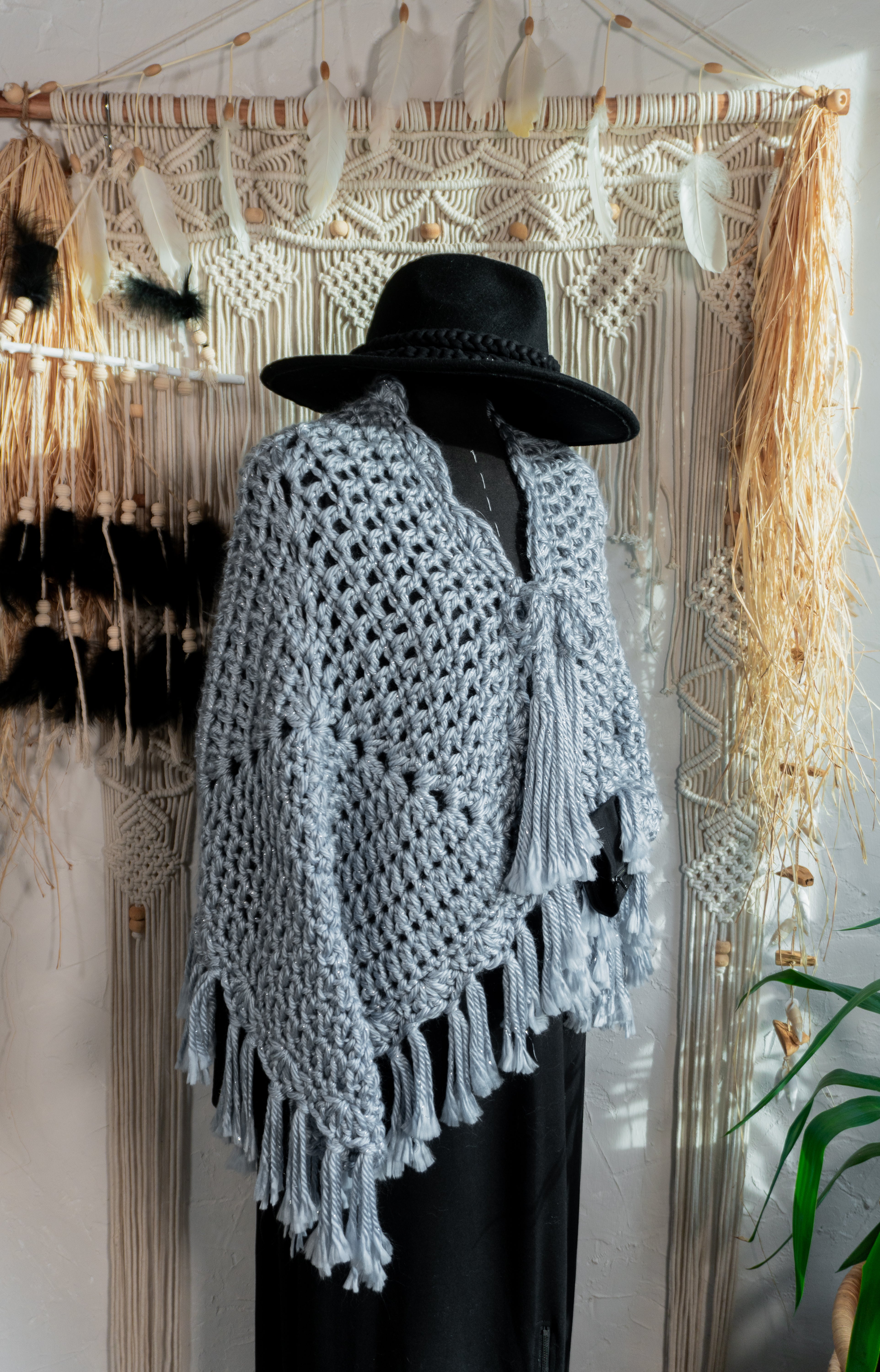 Verleihe deinem Outfit mit dem exklusiven Häkel Poncho-Jacke in Jeansblau-Grau-Metallic einen besonderen Boho-Chic Touch. Die schönen Fransen und Bänder am Ausschnitt sorgen für einen individuellen Look, perfekt für den Herbst oder Übergang. Hol dir jetzt dieses Einzelstück und begeistere mit edlem Design!