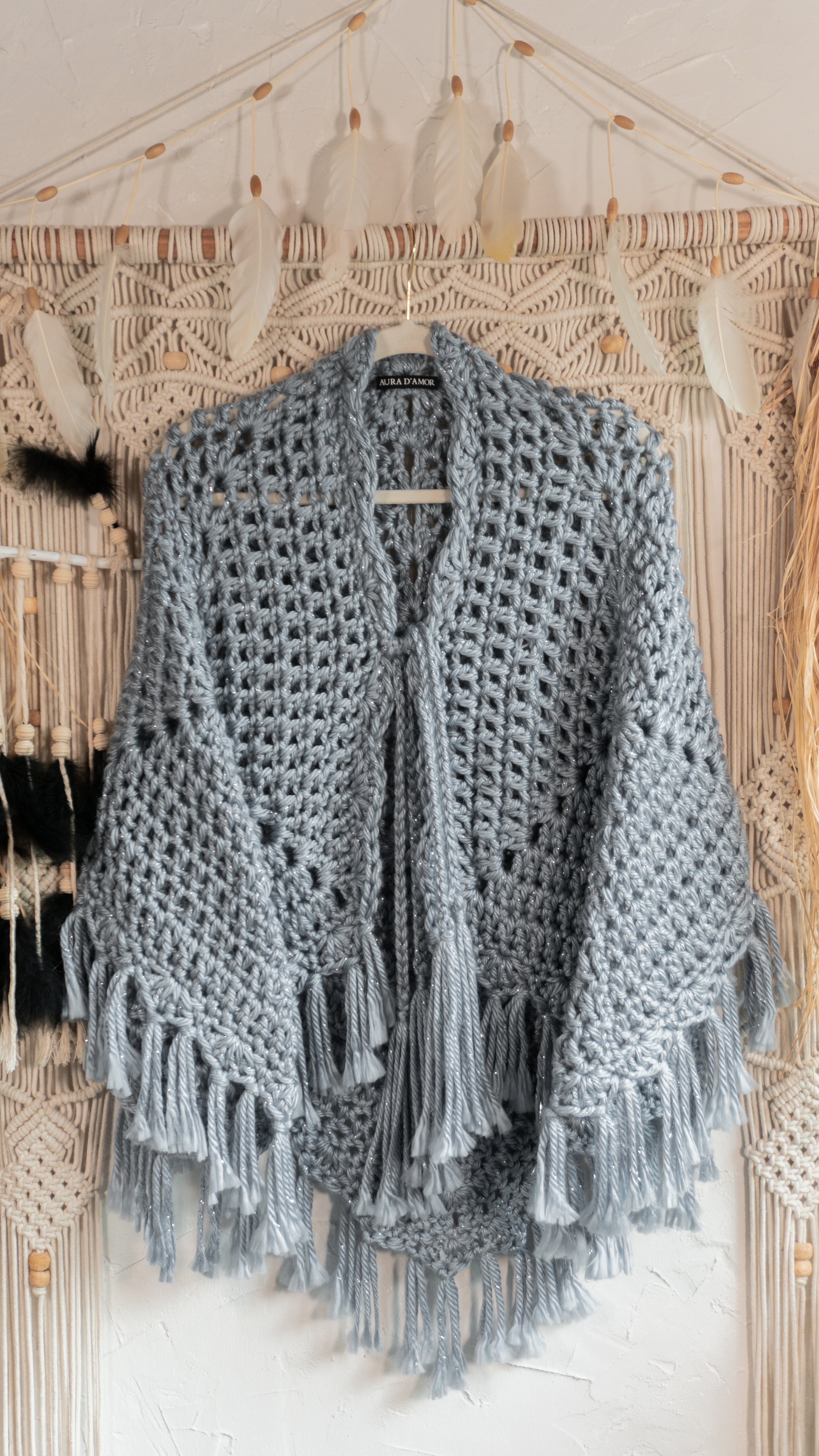 Verleihe deinem Outfit mit dem exklusiven Häkel Poncho-Jacke in Jeansblau-Grau-Metallic einen besonderen Boho-Chic Touch. Die schönen Fransen und Bänder am Ausschnitt sorgen für einen individuellen Look, perfekt für den Herbst oder Übergang. Hol dir jetzt dieses Einzelstück und begeistere mit edlem Design!