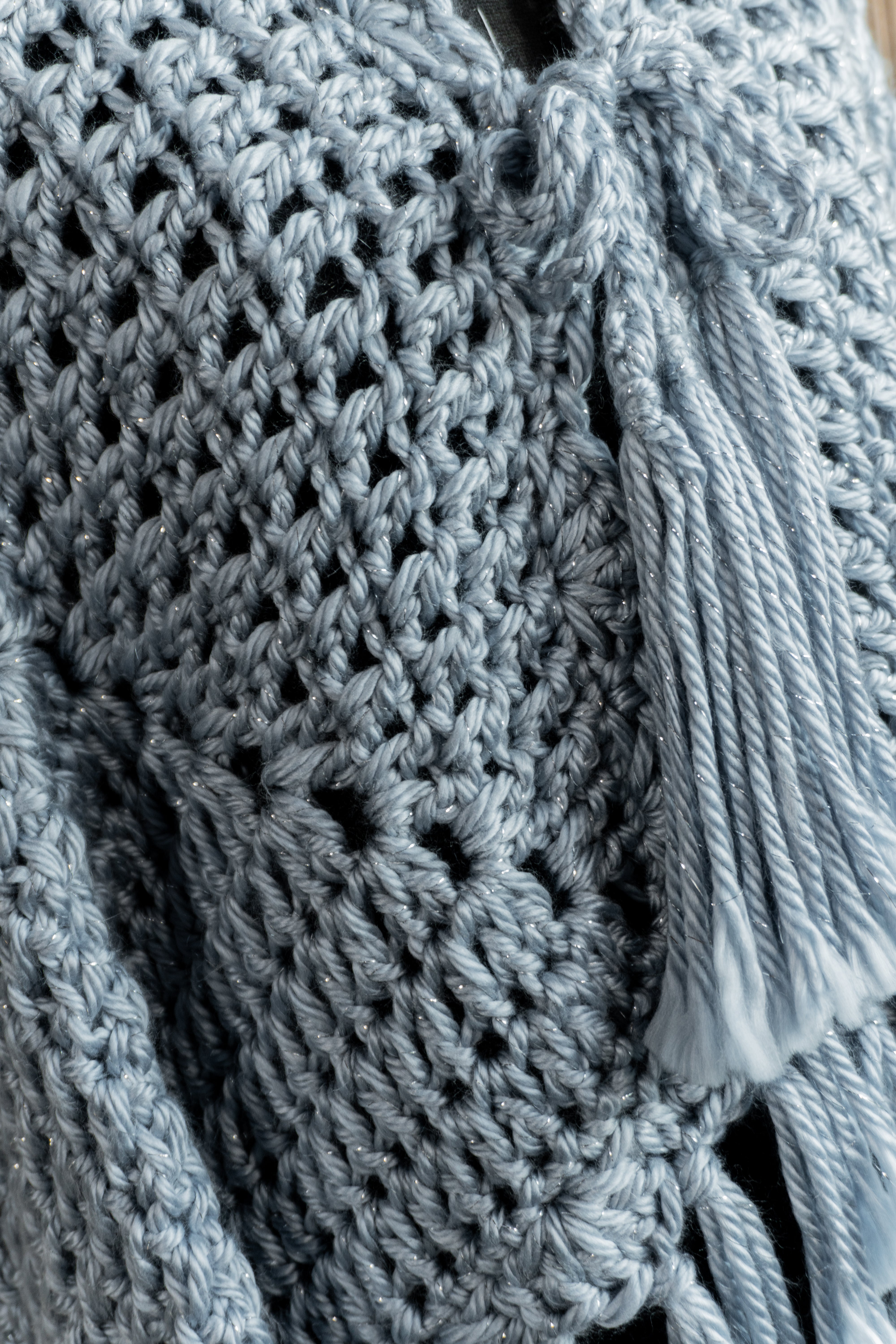 Verleihe deinem Outfit mit dem exklusiven Häkel Poncho-Jacke in Jeansblau-Grau-Metallic einen besonderen Boho-Chic Touch. Die schönen Fransen und Bänder am Ausschnitt sorgen für einen individuellen Look, perfekt für den Herbst oder Übergang. Hol dir jetzt dieses Einzelstück und begeistere mit edlem Design!