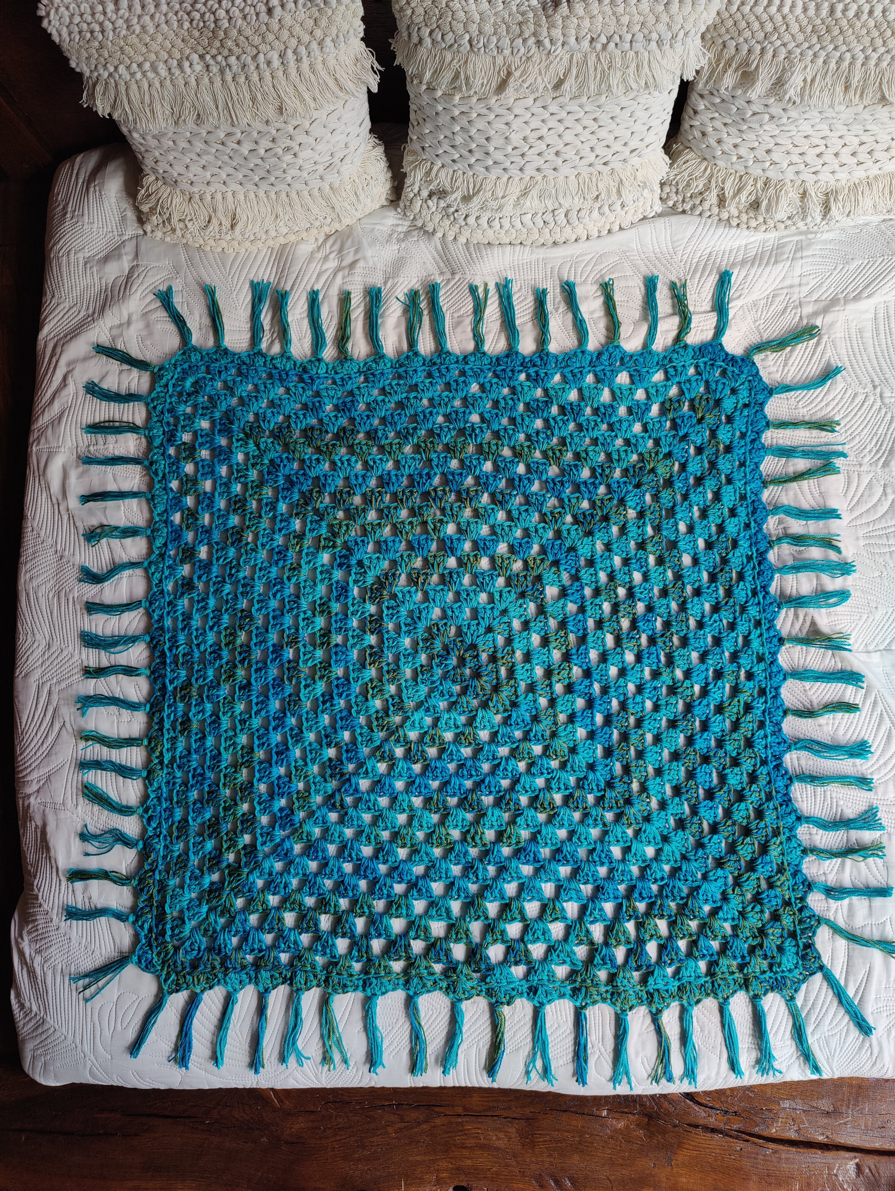 Handgefertigte Boho Häkeldecke im Farbmix Blau, Türkis und Khaki mit Fransen. Quadratische Decke als Babydecke, Kinderdecke, Sofadecke oder Tagesdecke im Ibiza Boho Style.
