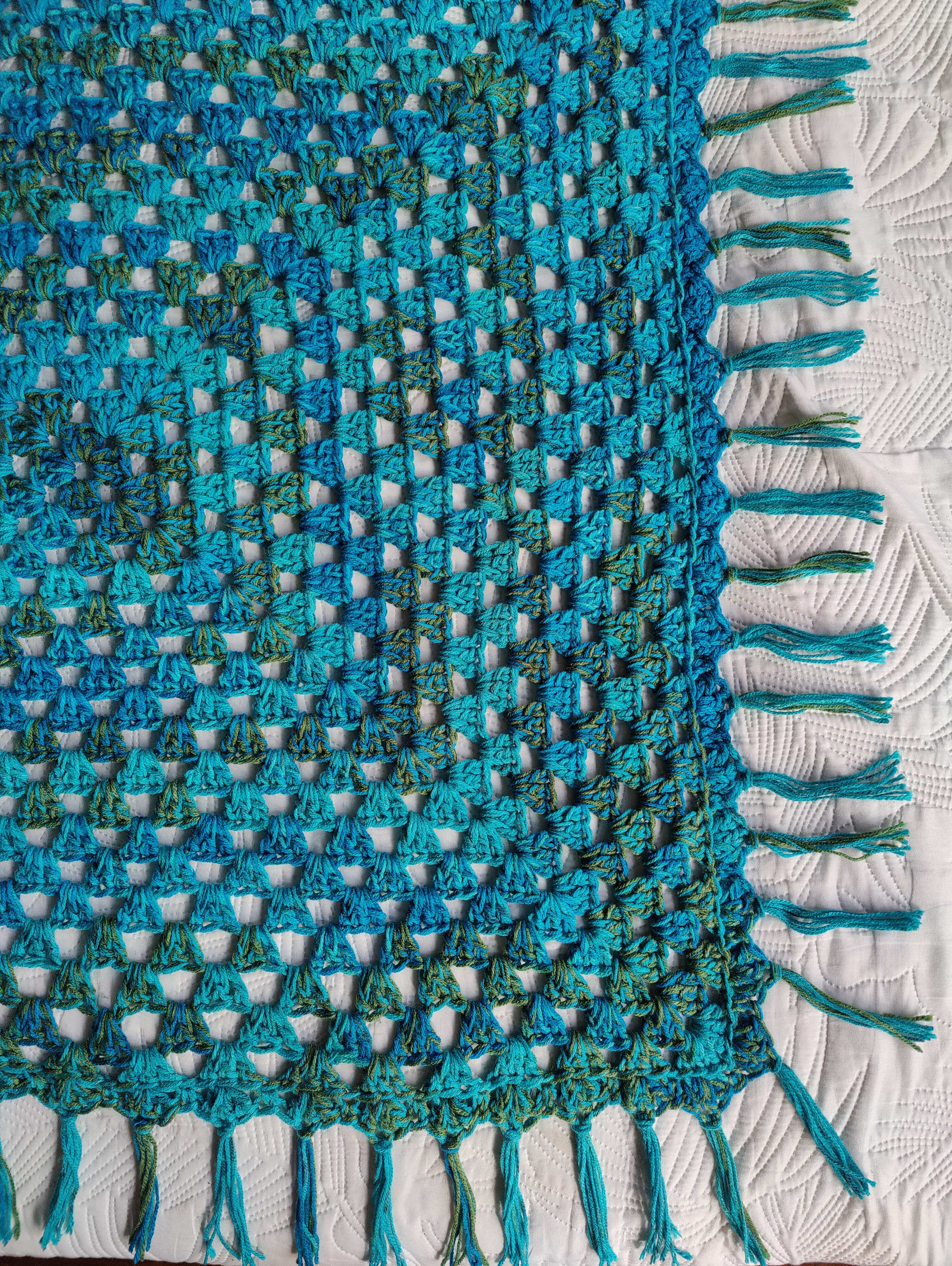 Handgefertigte Boho Häkeldecke im Farbmix Blau, Türkis und Khaki mit Fransen. Quadratische Decke als Babydecke, Kinderdecke, Sofadecke oder Tagesdecke im Ibiza Boho Style.