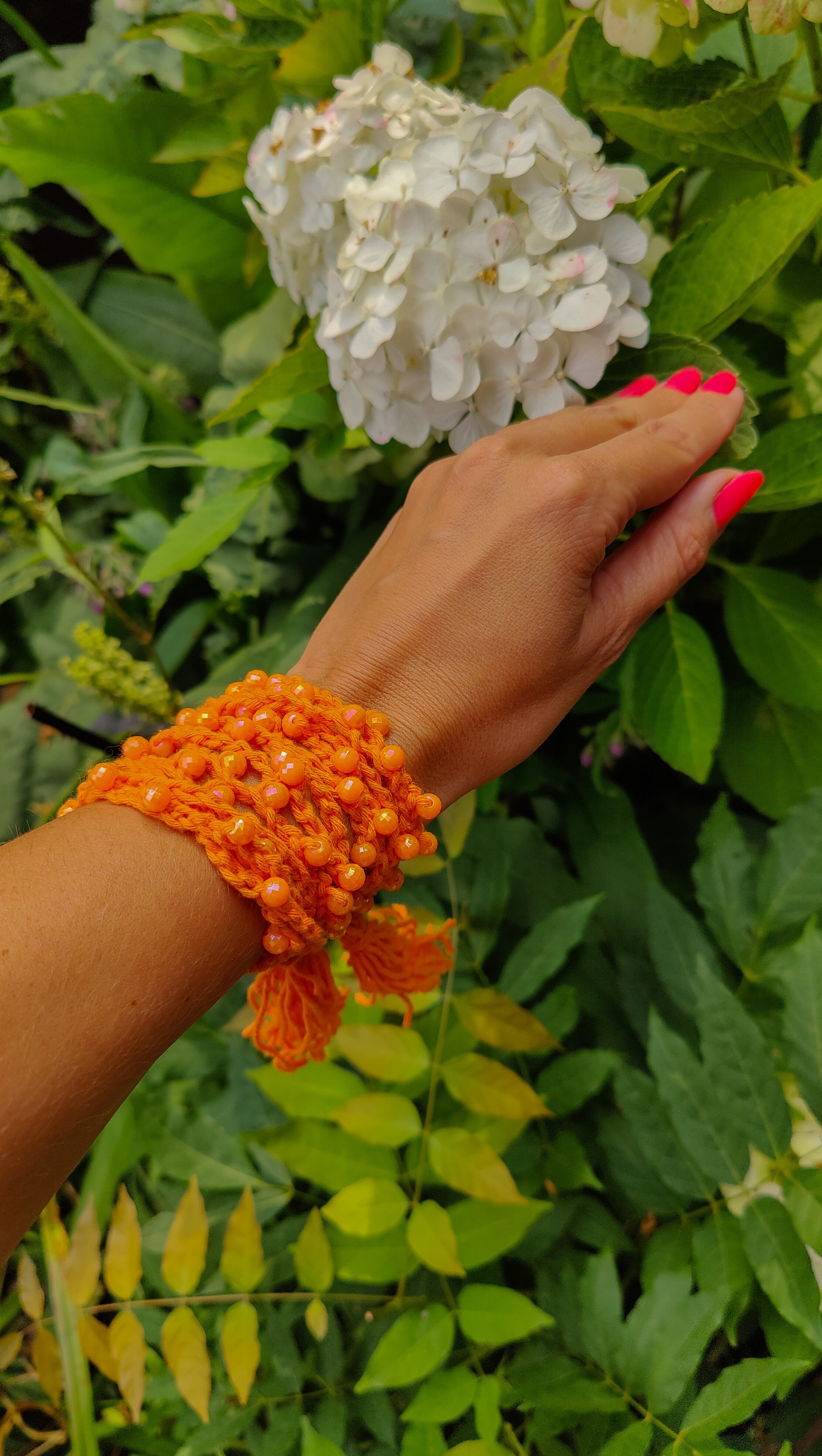 Handgemachte orangefarbene Boho-Häkelkette mit Perlen, variabel tragbar als Halskette, Armband oder Taillengürtel – Ibiza-Style Schmuck für Sommerlooks.