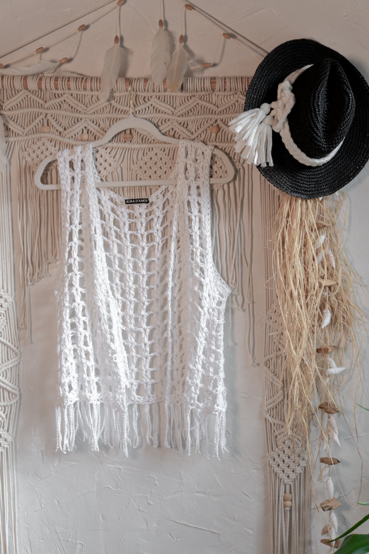 Weiße handgefertigte Häkelweste aus merzerisierter Baumwolle mit langen Fransen und Bindeband. Boho Sommerweste im Ibiza Style für Strand, Urlaub und Festivals.